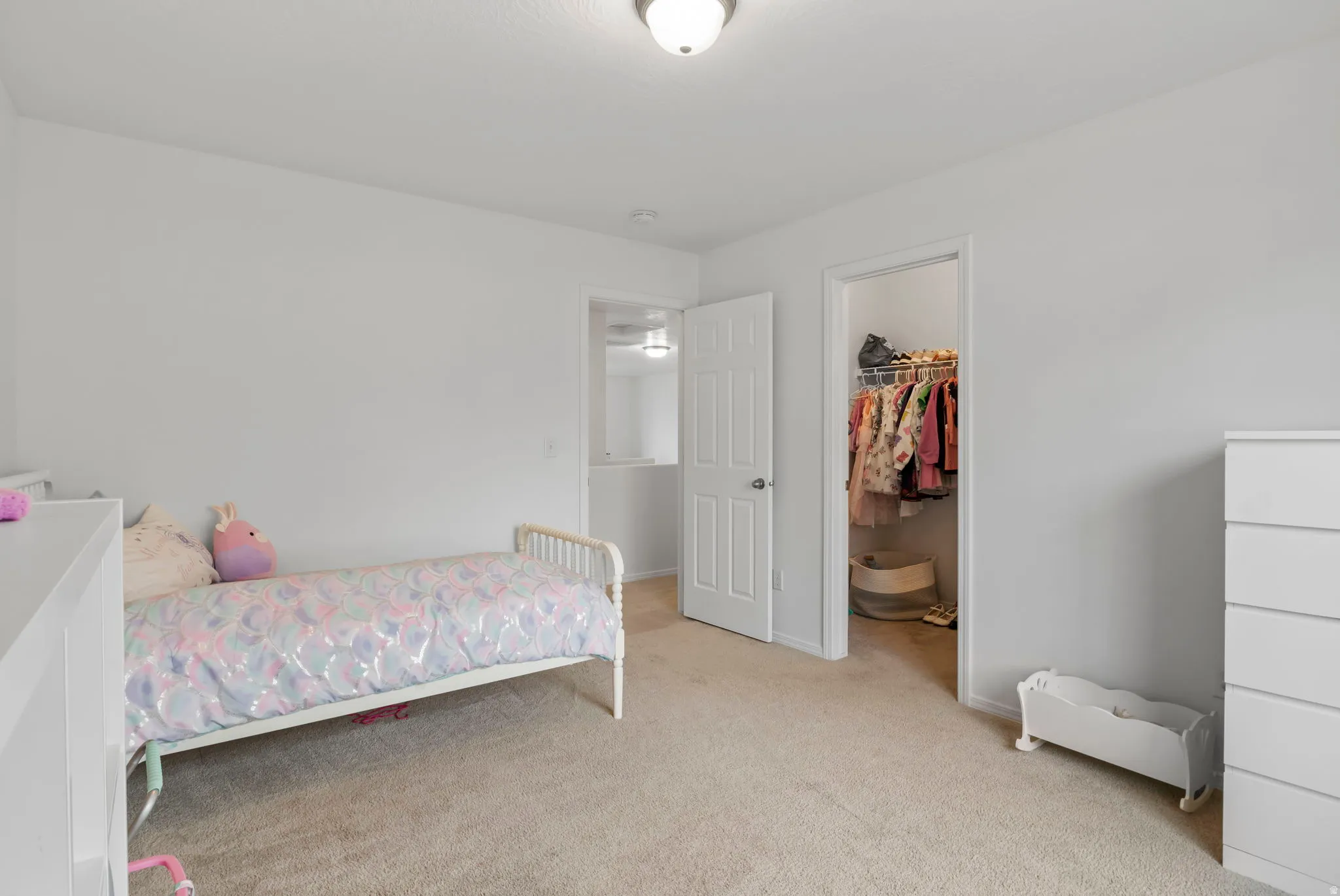 Bedroom with a spacious closet and light colored carpet
