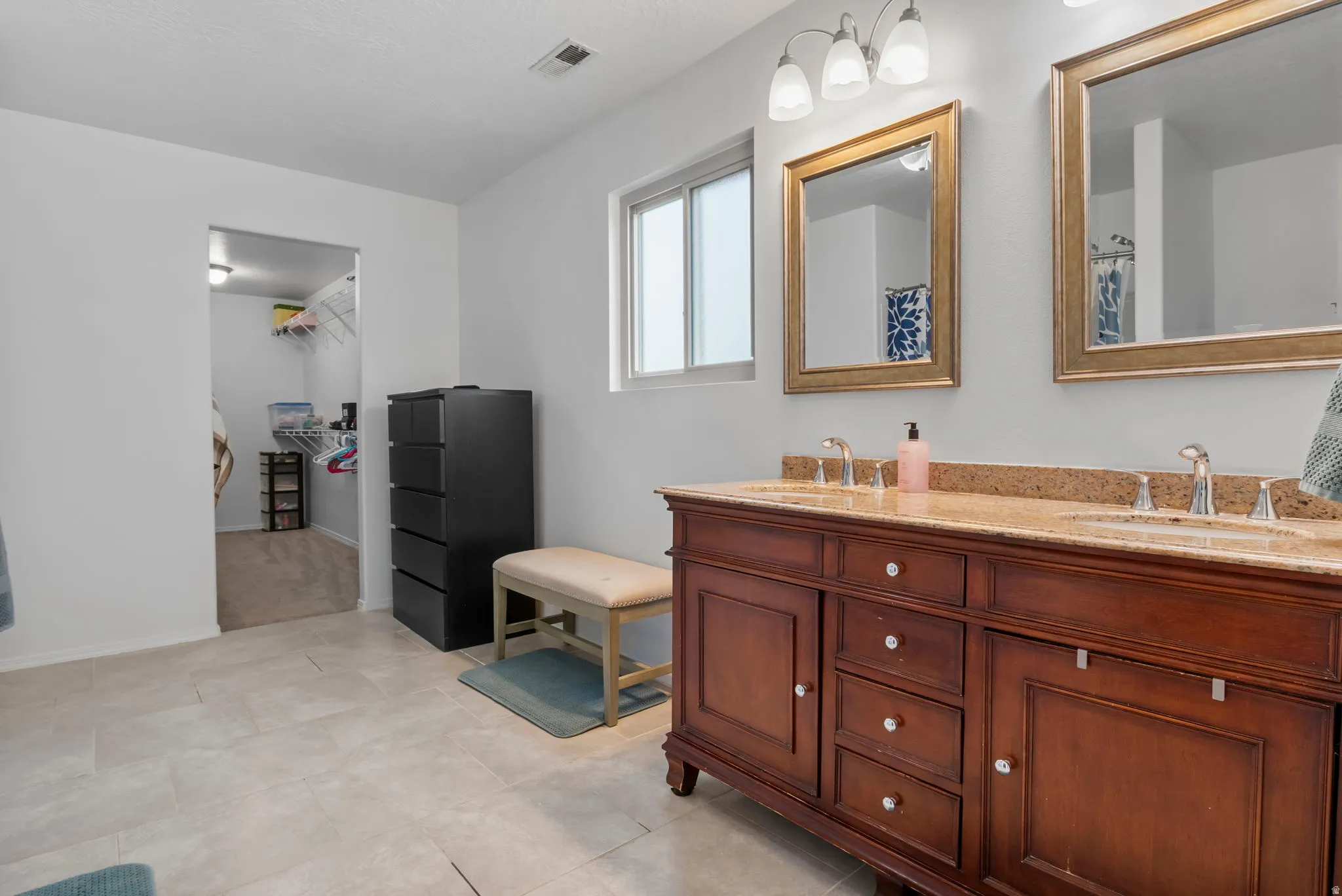 Bathroom featuring double vanity and a walk in closet