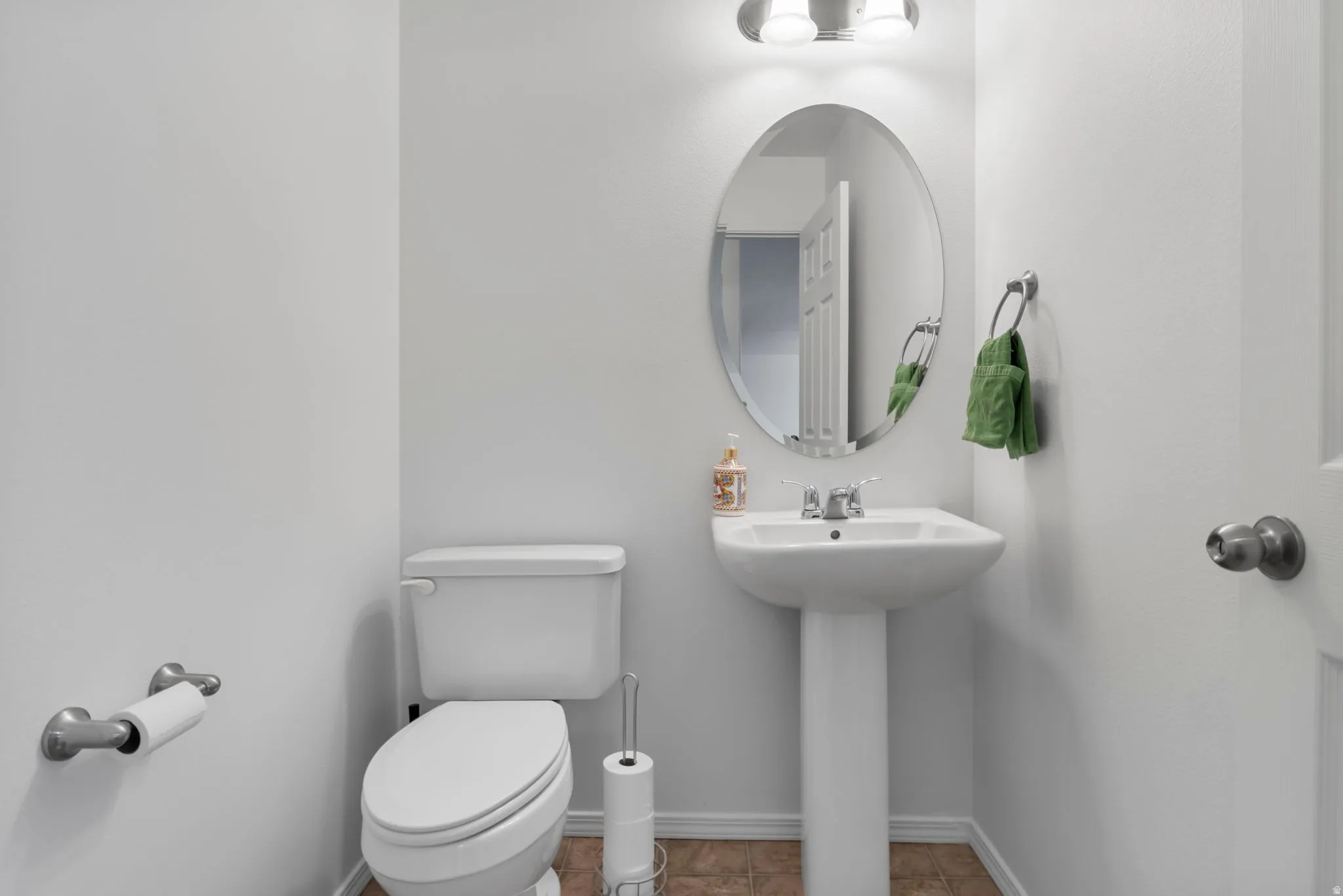 Half bathroom with baseboards and tile patterned flooring