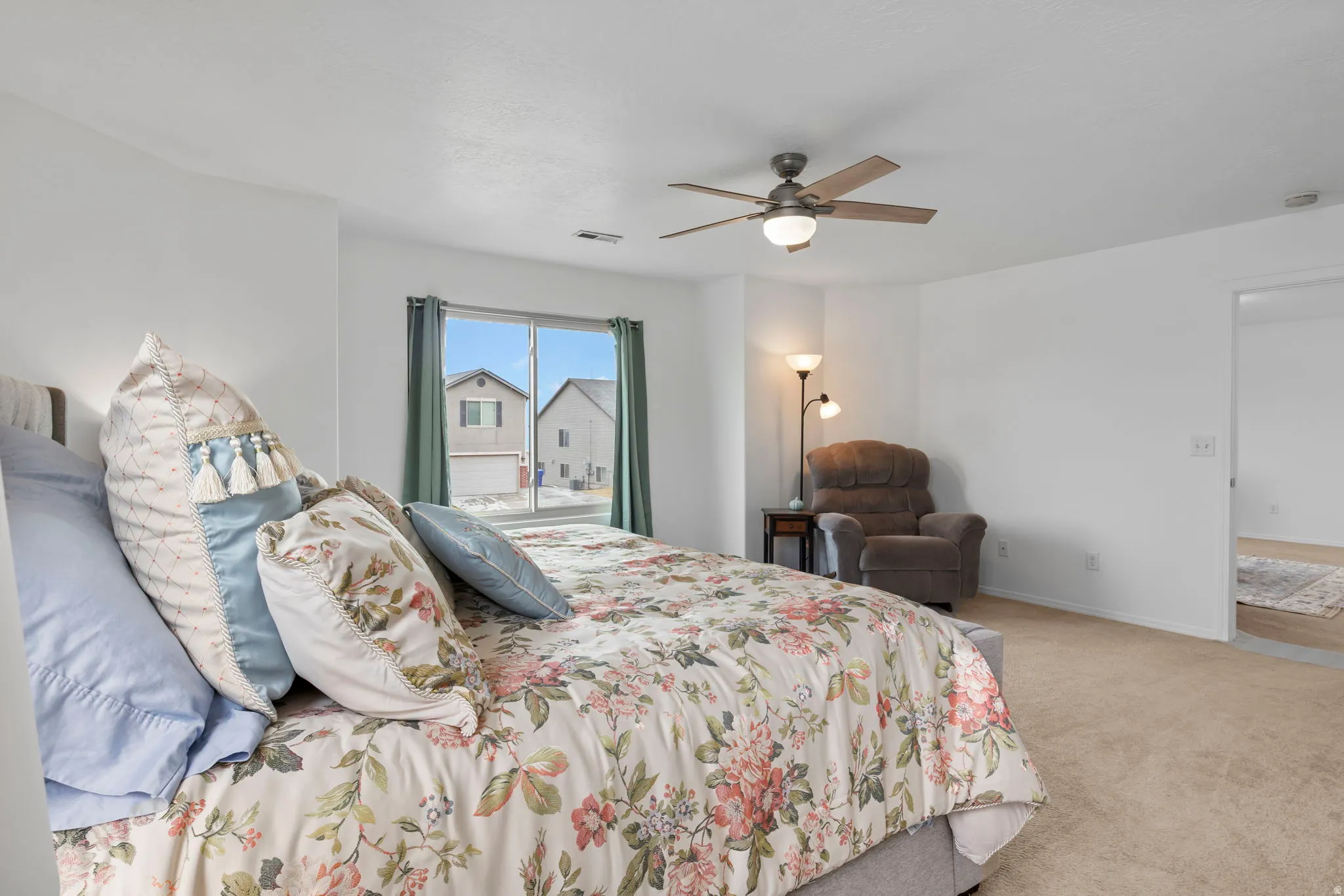 Bedroom with light carpet and a ceiling fan