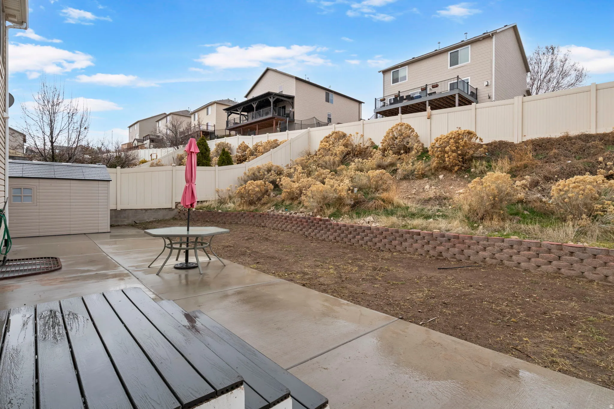 Fenced backyard featuring a storage shed, a patio, and outdoor dining space