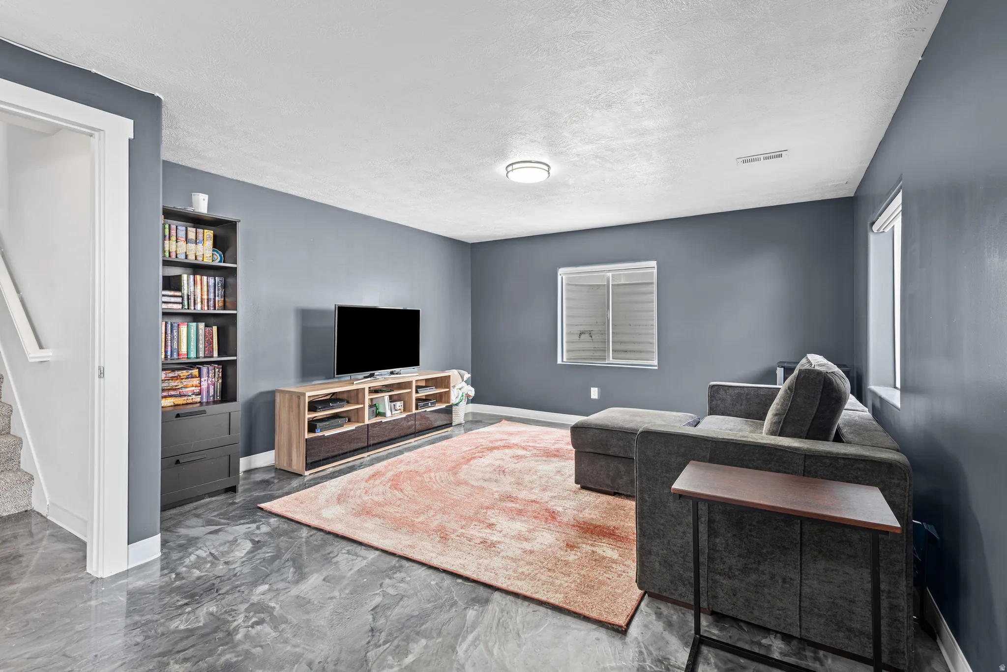 Living room with a textured ceiling and marble finish flooring