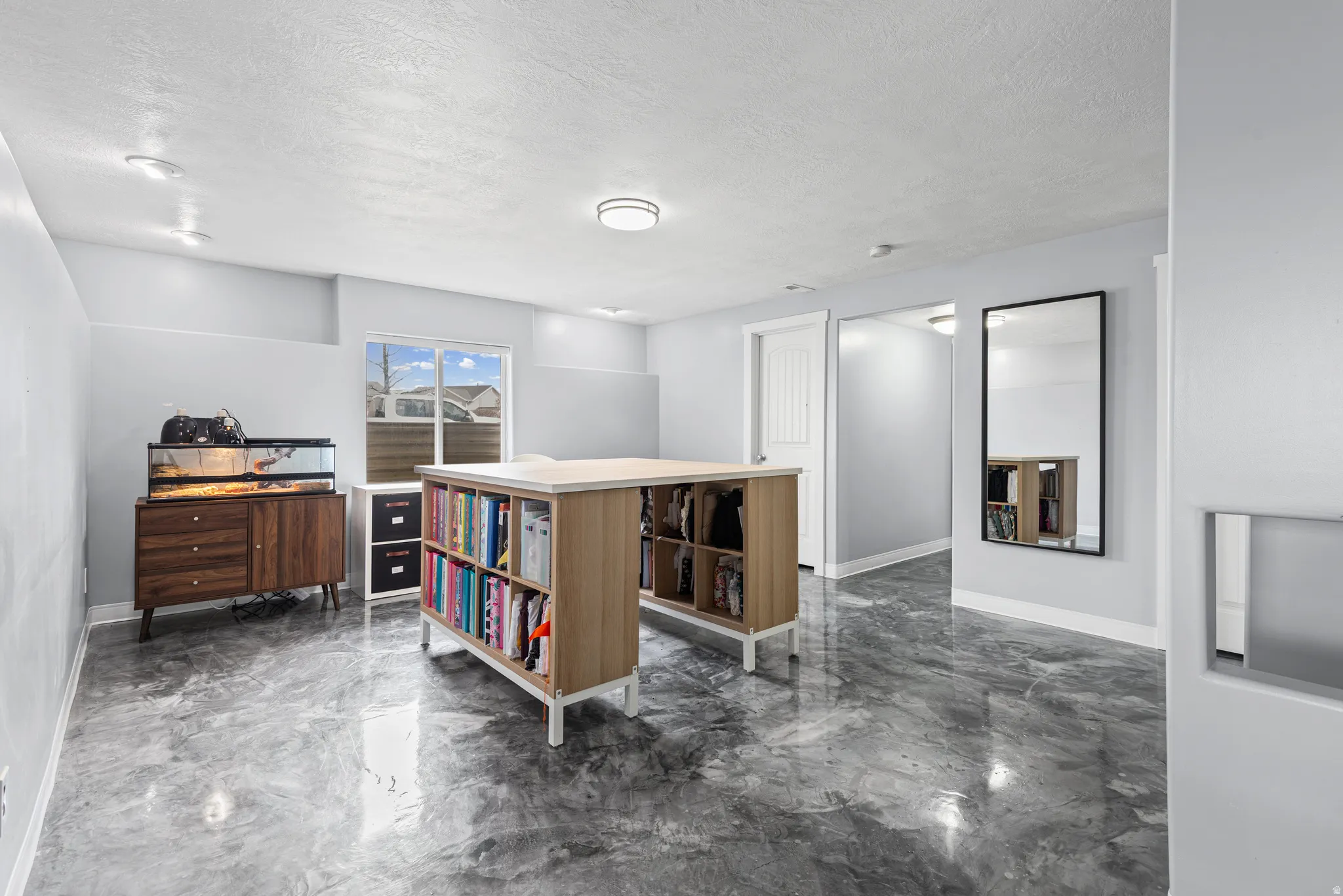 Office space featuring dark marble finish flooring and a textured ceiling