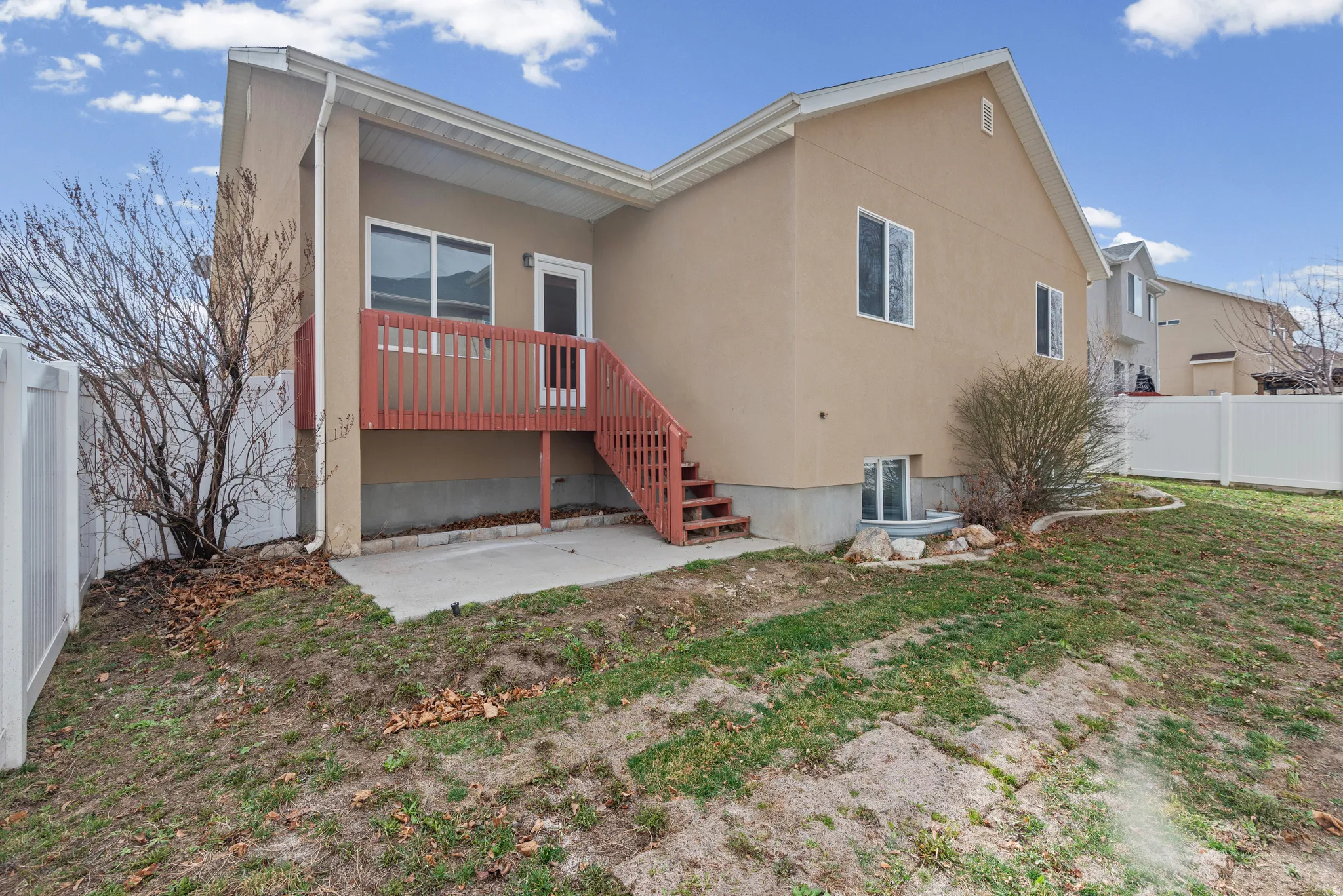 Rear view of house with a fenced backyard, a patio area, and stucco siding