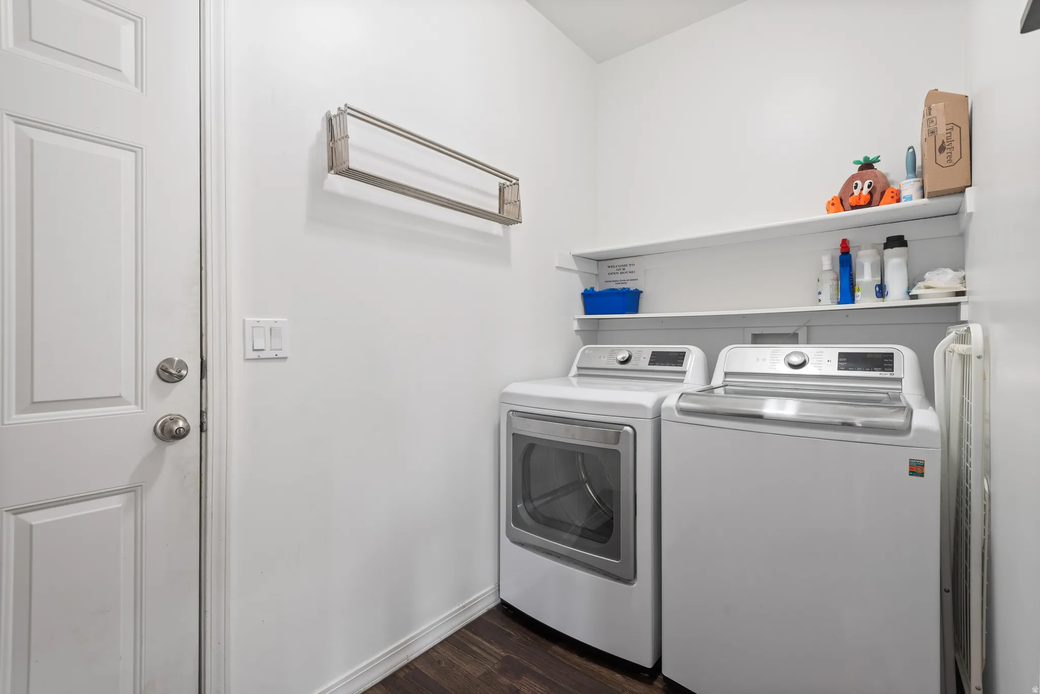 Laundry room with dark wood-type flooring and washer and clothes dryer