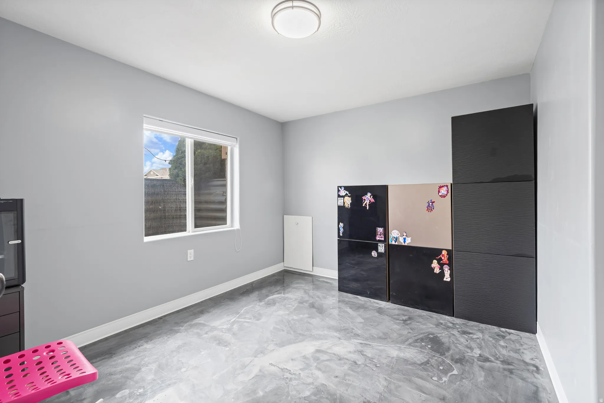 Misc room with concrete flooring and baseboards