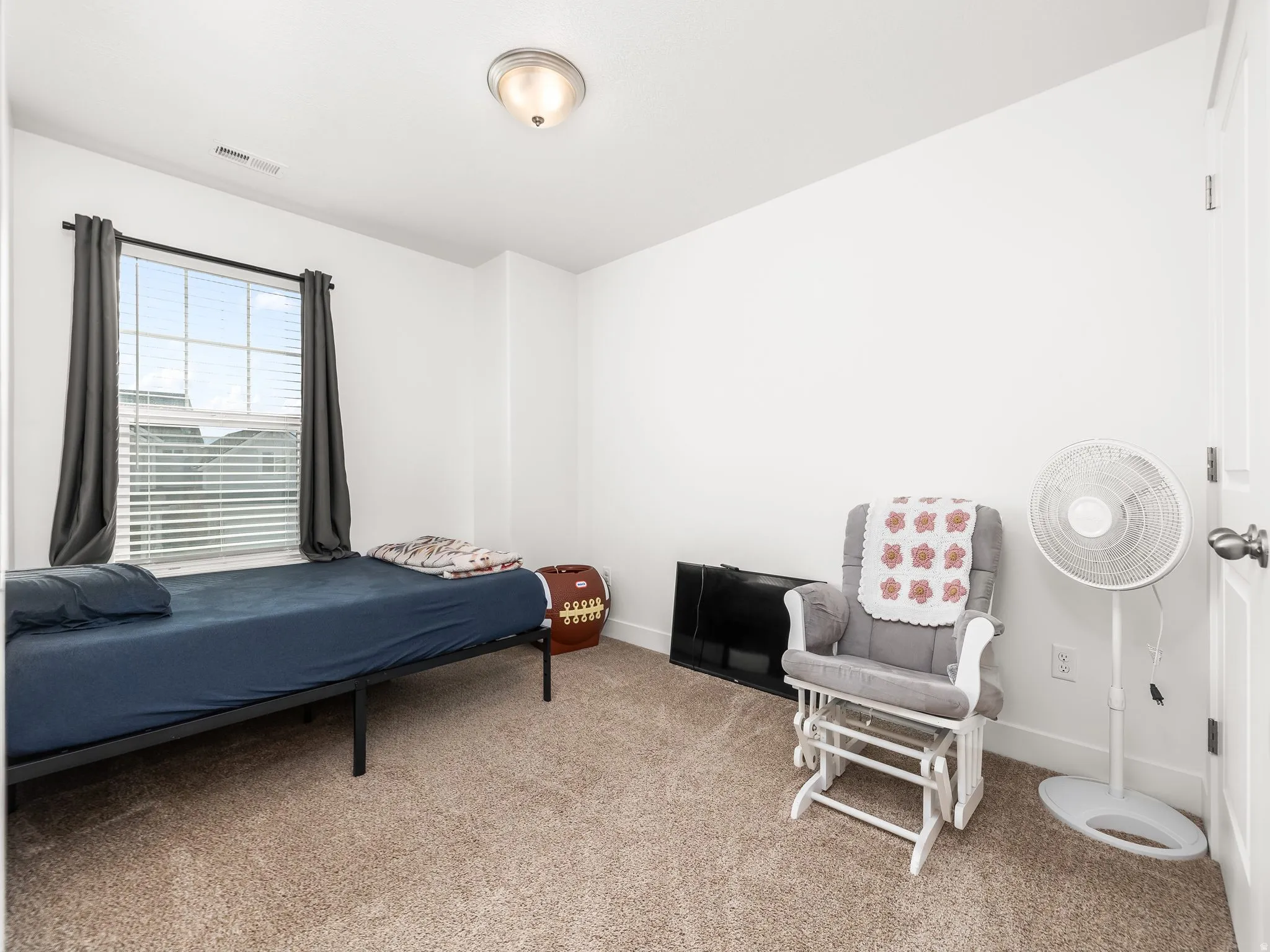 Bedroom with light colored carpet and baseboards