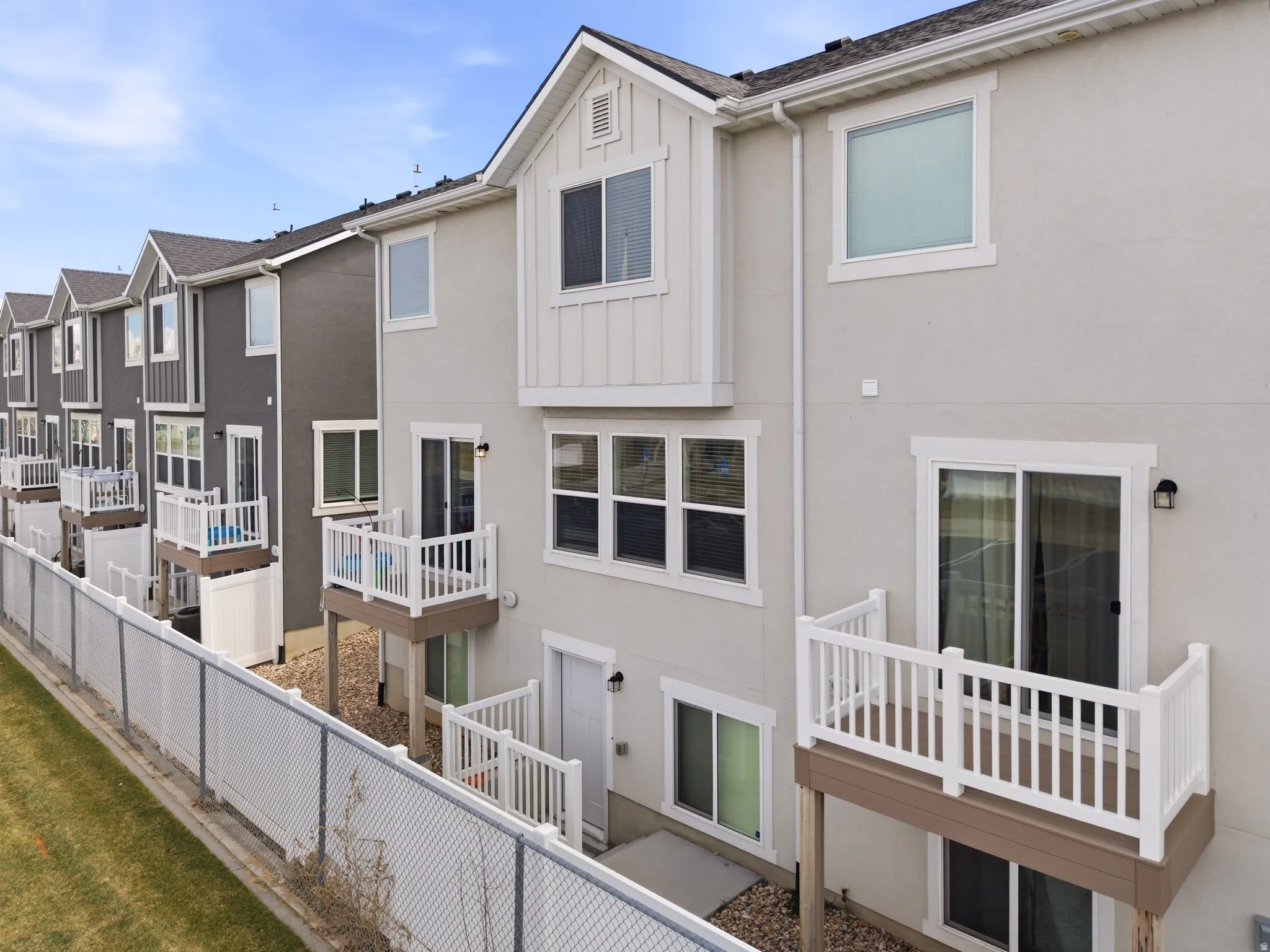 Back of property featuring a residential view, board and batten siding, and stucco siding