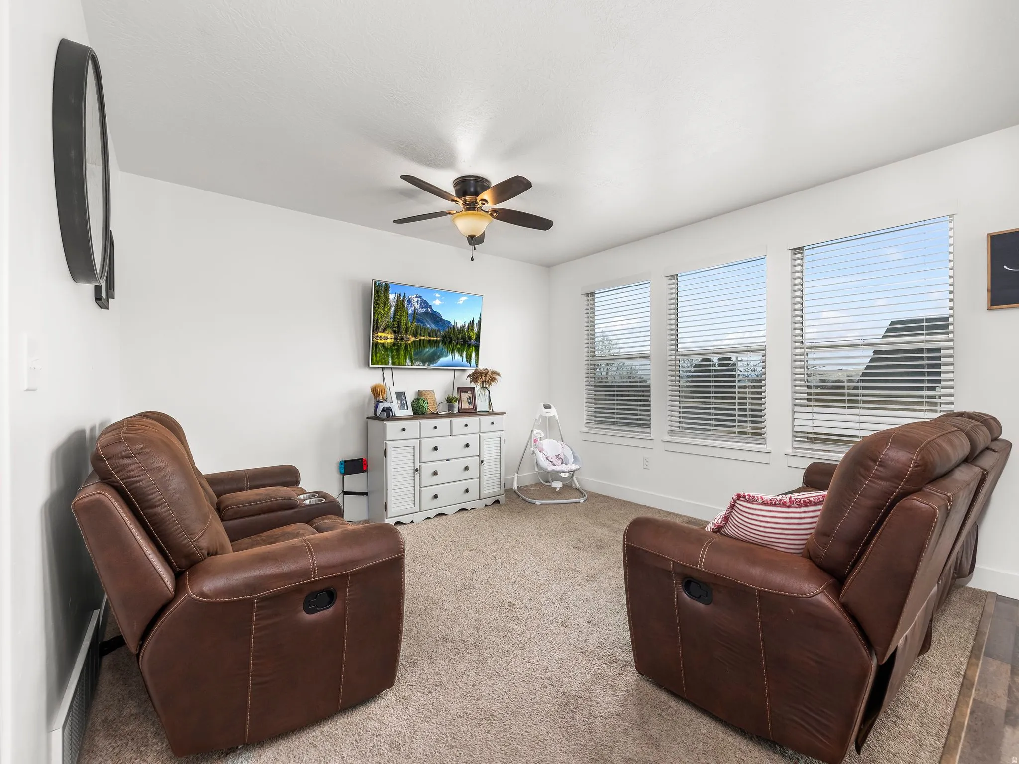 Sitting room with carpet and a ceiling fan