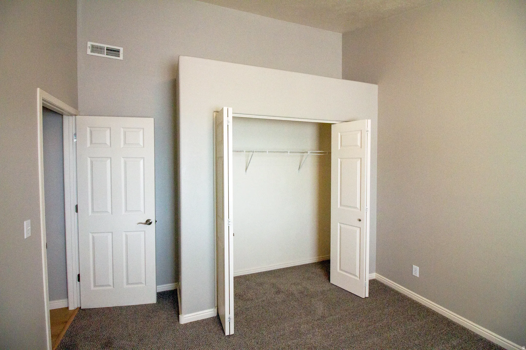 Unfurnished bedroom featuring a closet and dark colored carpet