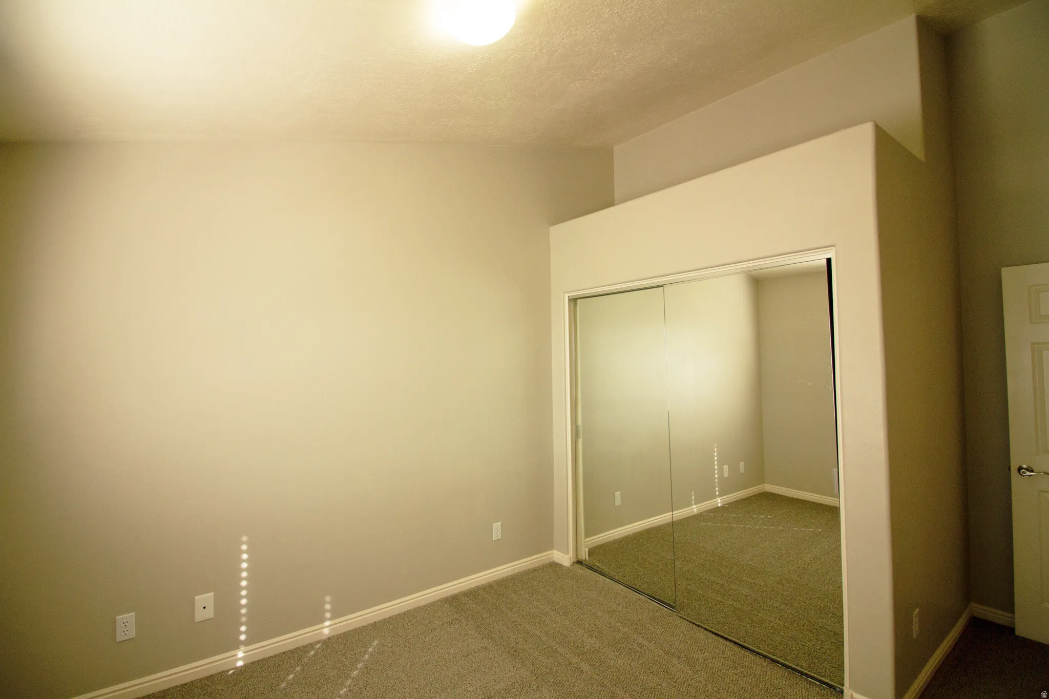 Unfurnished bedroom featuring dark colored carpet and a closet