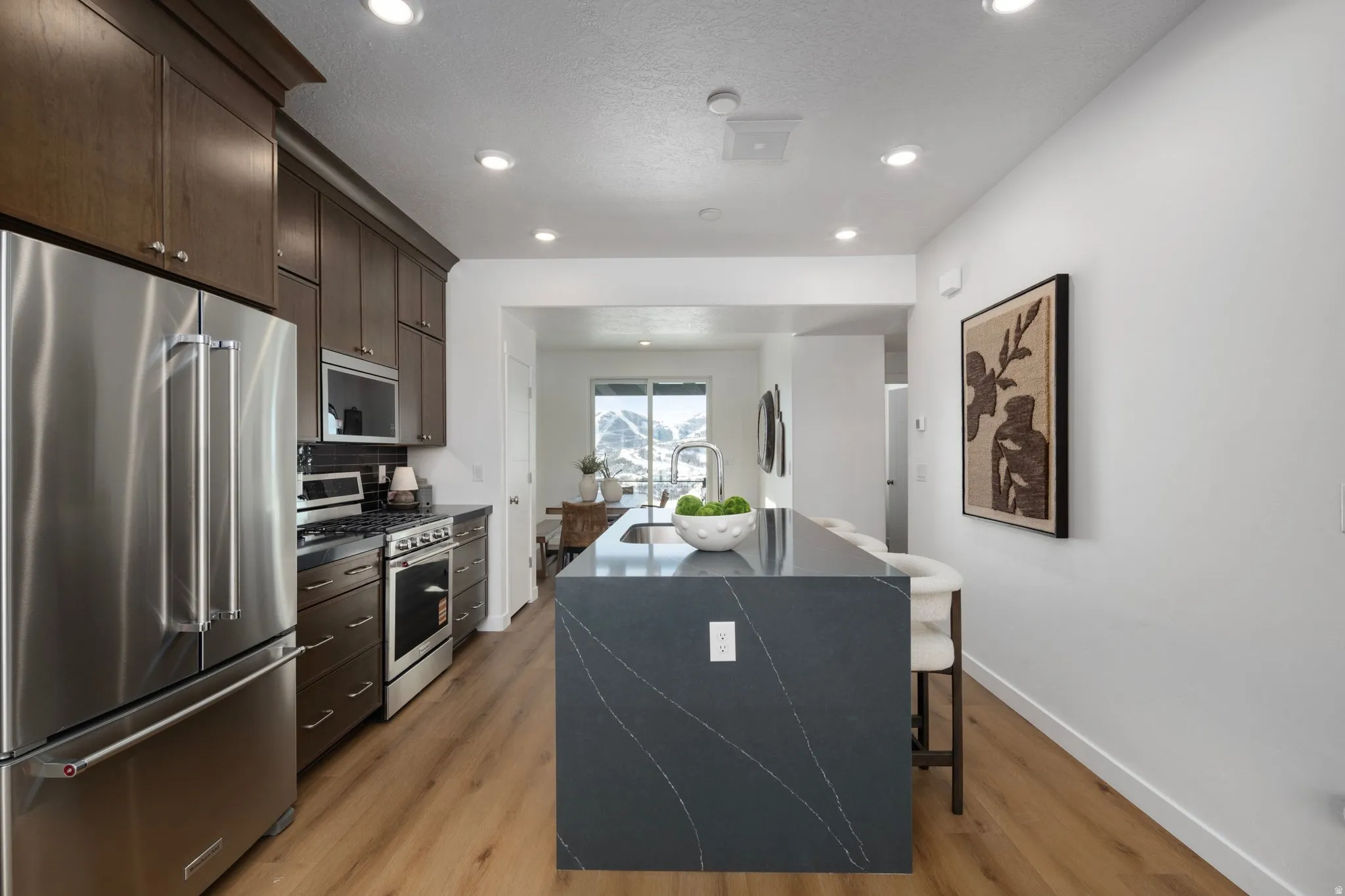 Sleek quartz countertops and modern cabinetry create a stylish yet functional space. *Model Home
