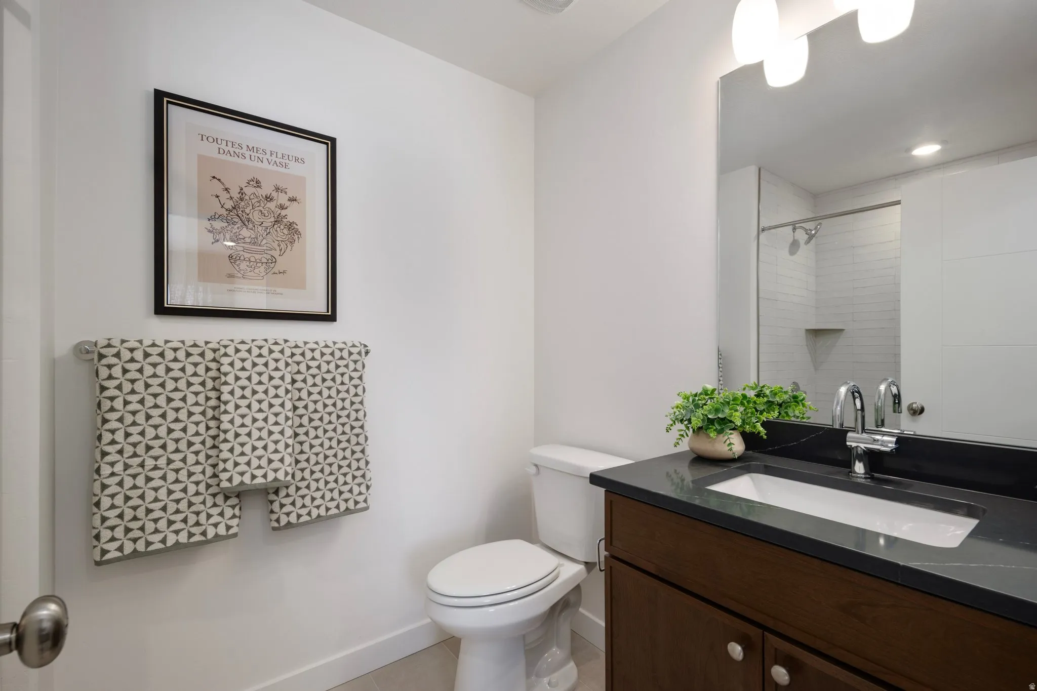 Bathroom featuring vanity, light tile patterned flooring, and a shower