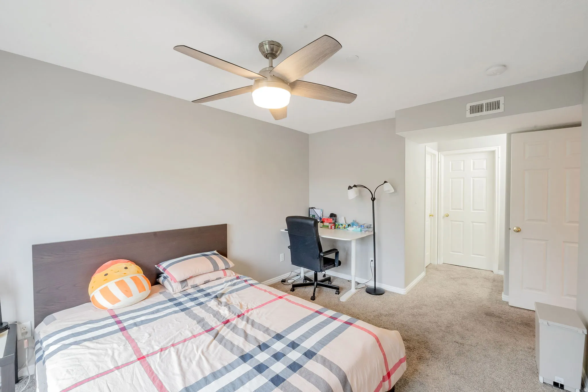 Neutral-toned bedroom featuring wall-to-wall carpeting and a ceiling fan with integrated lighting
