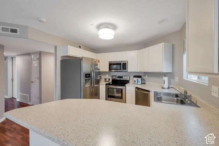 Kitchen featuring white cabinetry, stainless steel appliances.