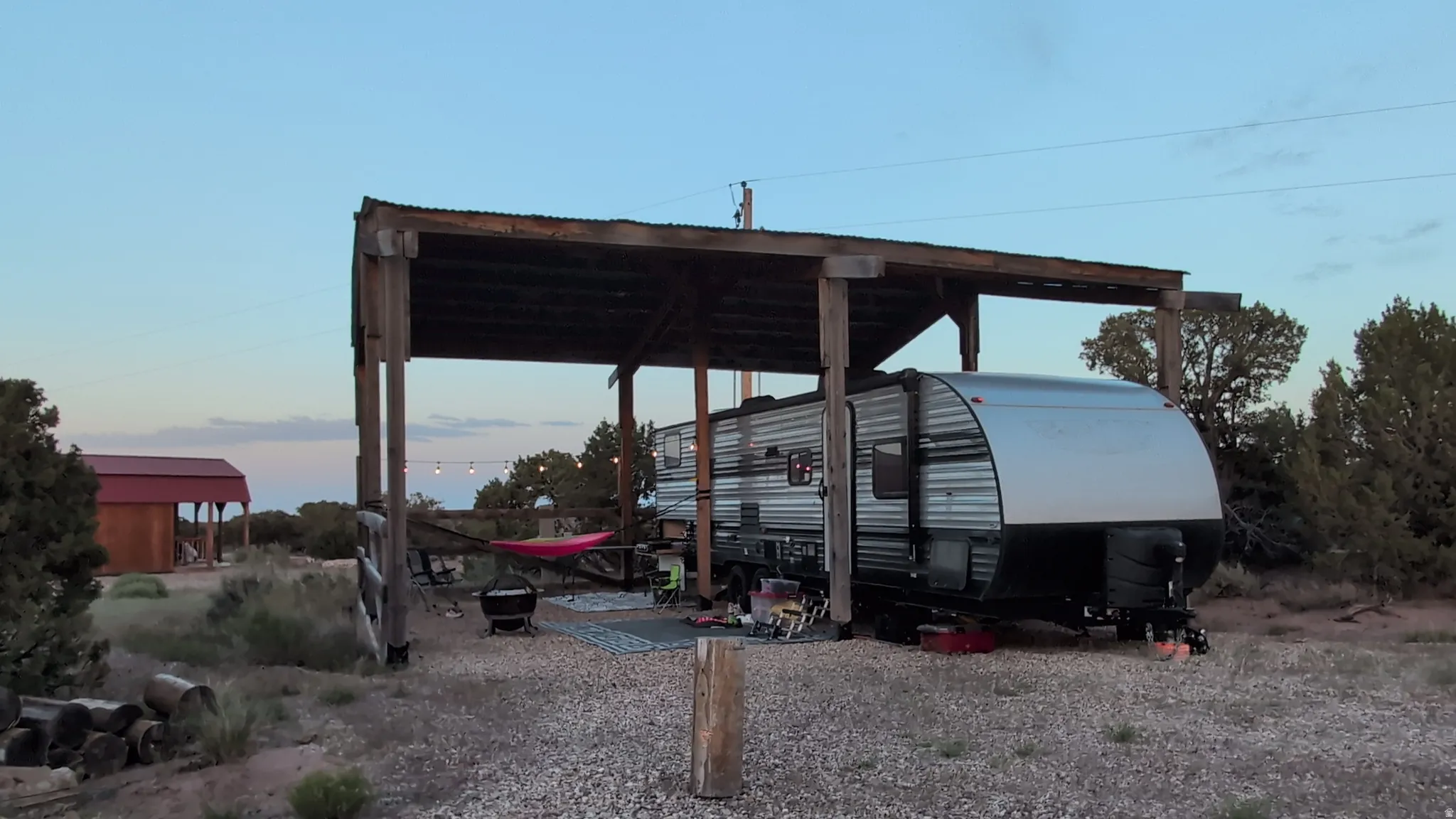 Gravel pad with a wooden open-air structure providing covered space