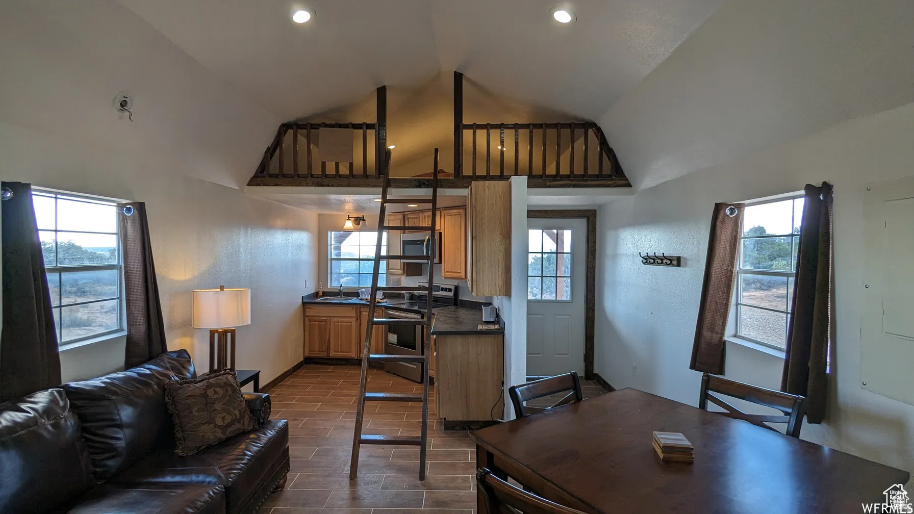Living room featuring vaulted ceiling and baseboards