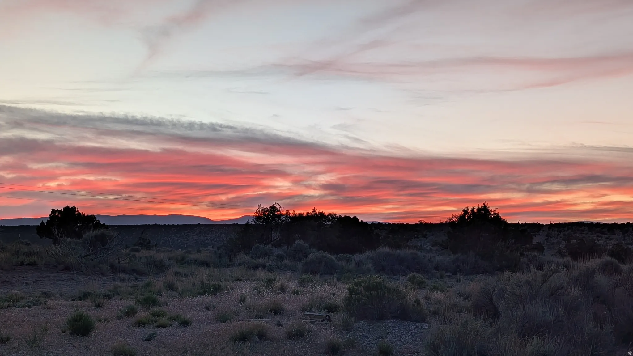 Desert landscape with a vibrant sunset providing a colorful sky backdrop