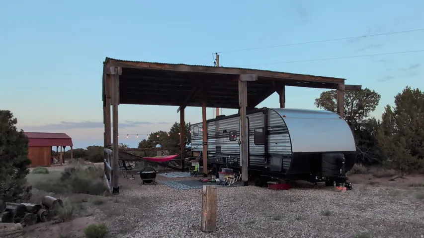 Gravel pad with a wooden open-air structure providing covered space