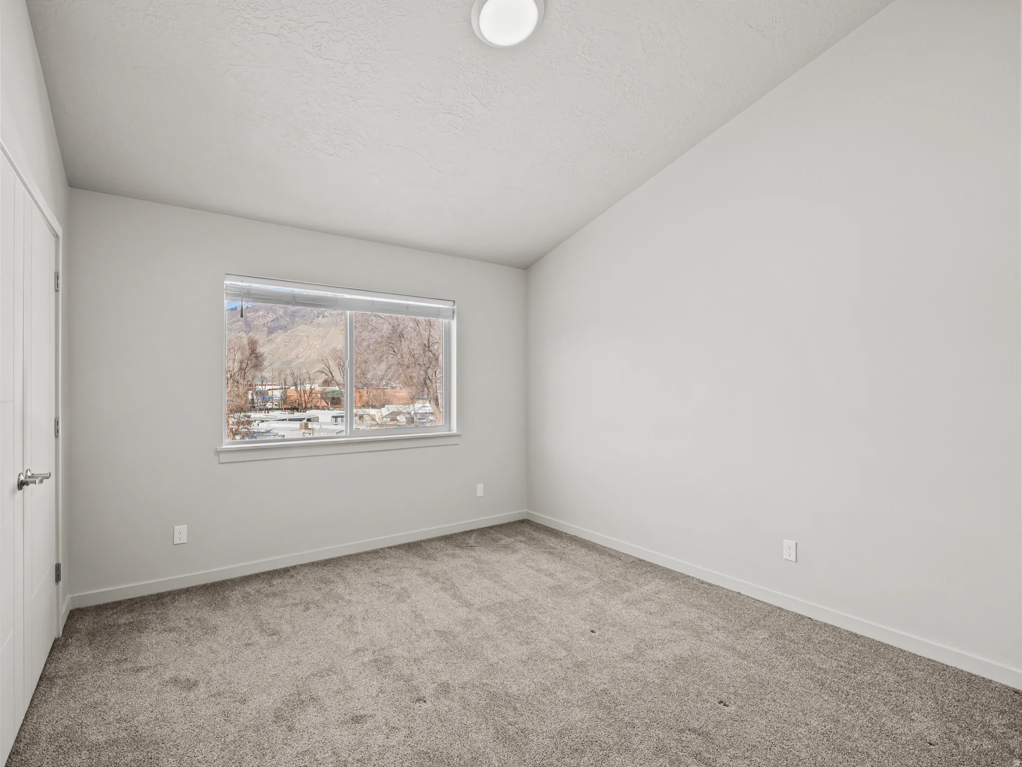 Carpeted spare room featuring baseboards