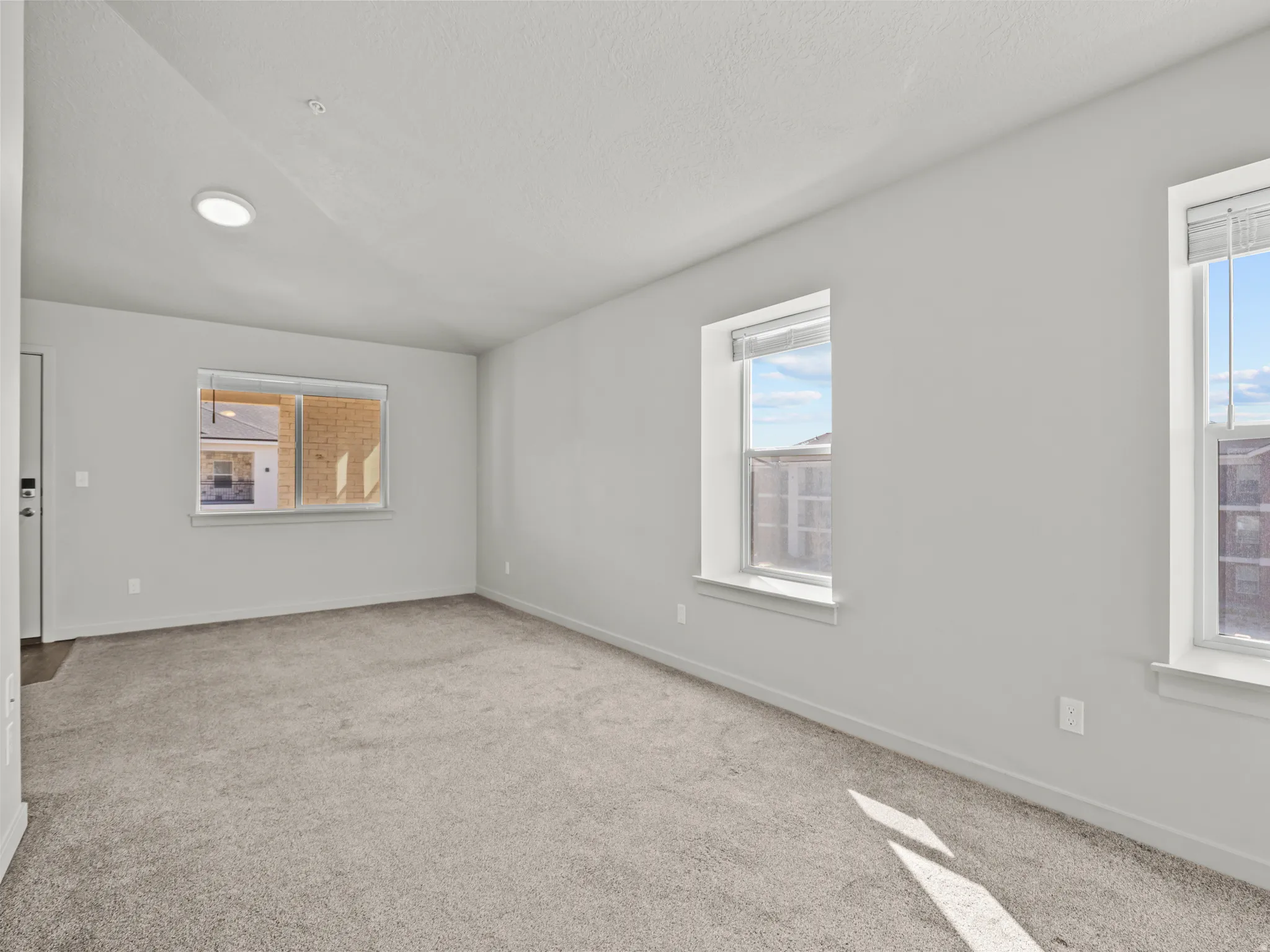 Carpeted empty room featuring plenty of natural light and a textured ceiling