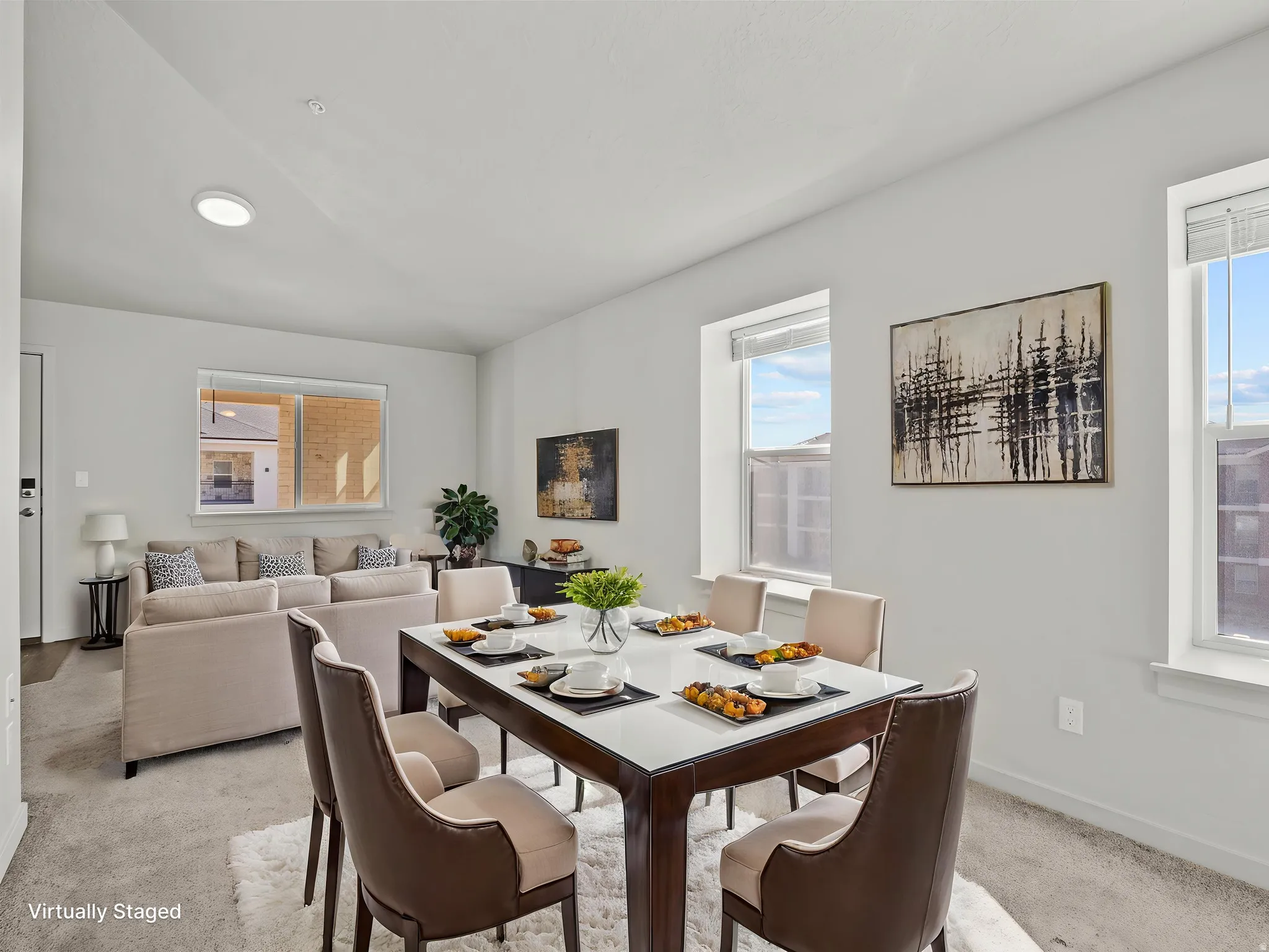 Open-concept living and dining areas featuring neutral wall tones, multiple windows, and carpet flooring