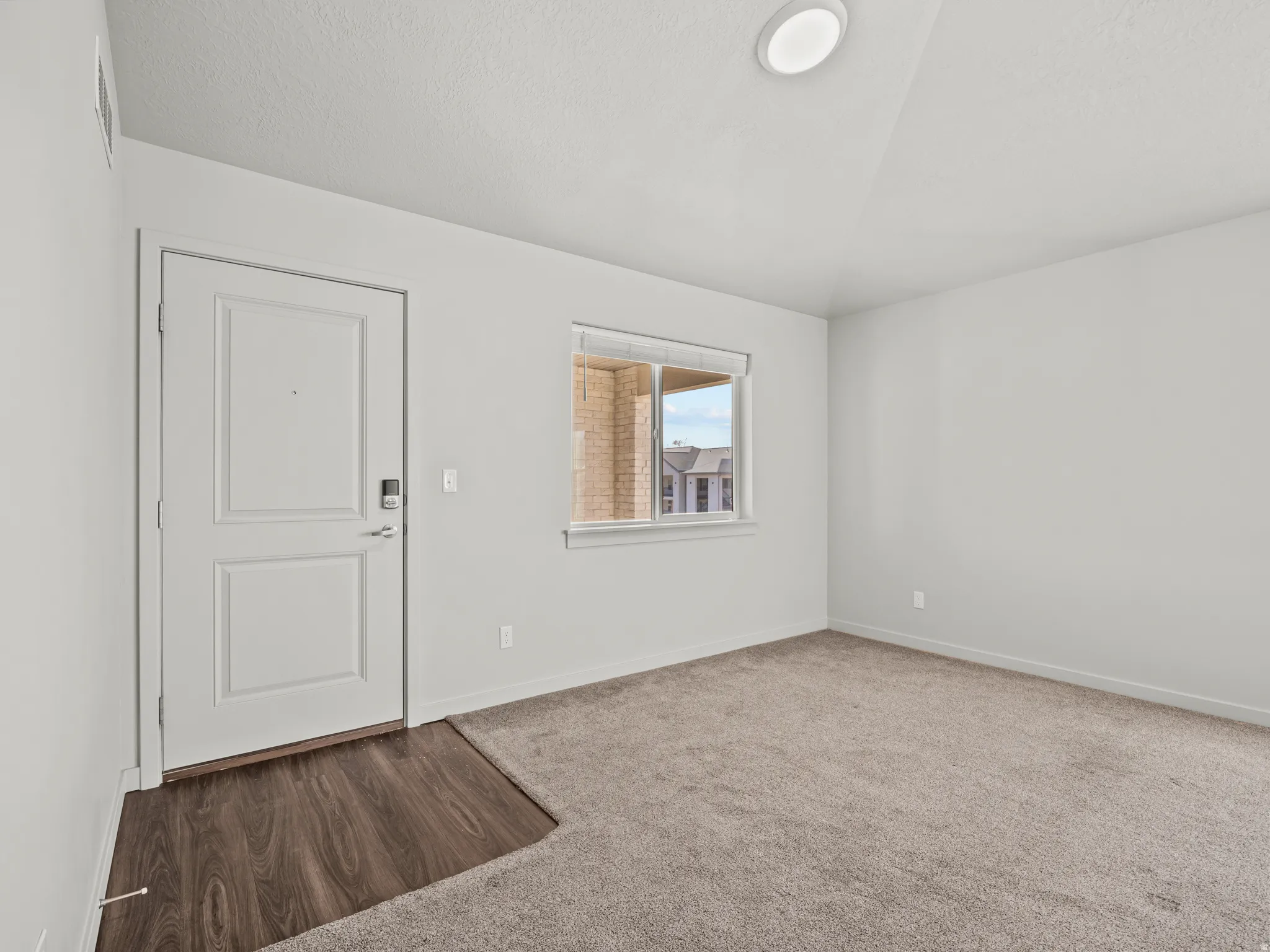 Entryway with carpet floors and wood finished floors