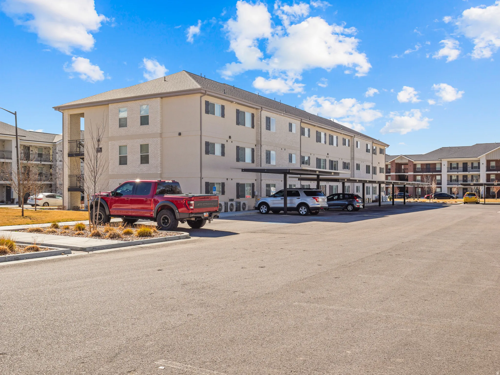 View of apartment building / complex featuring uncovered parking