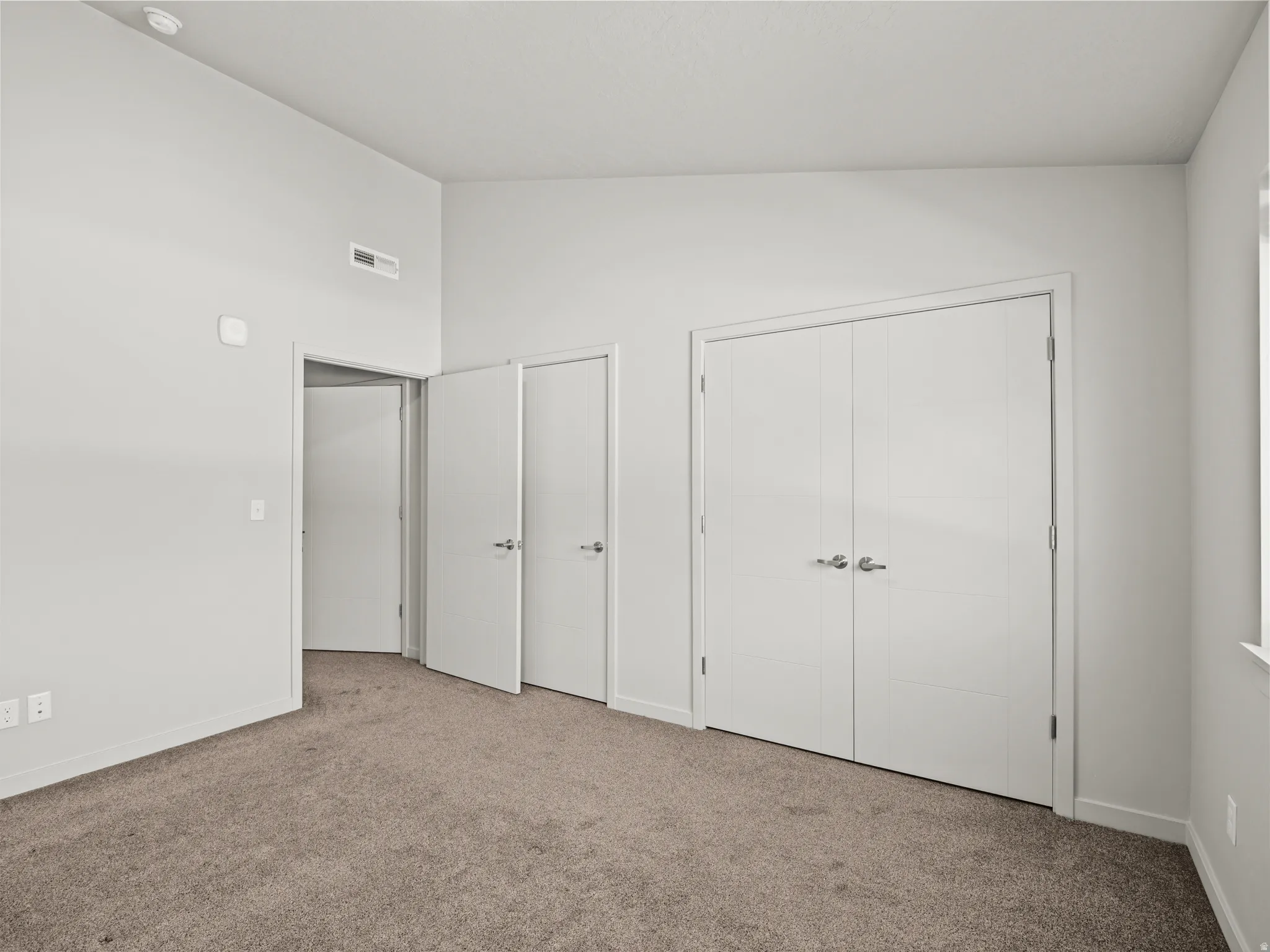 Unfurnished bedroom with carpet, lofted ceiling, and a closet