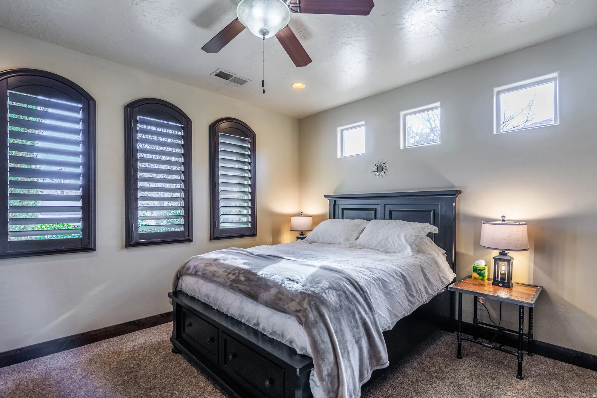 Bedroom featuring a ceiling fan and dark colored carpet