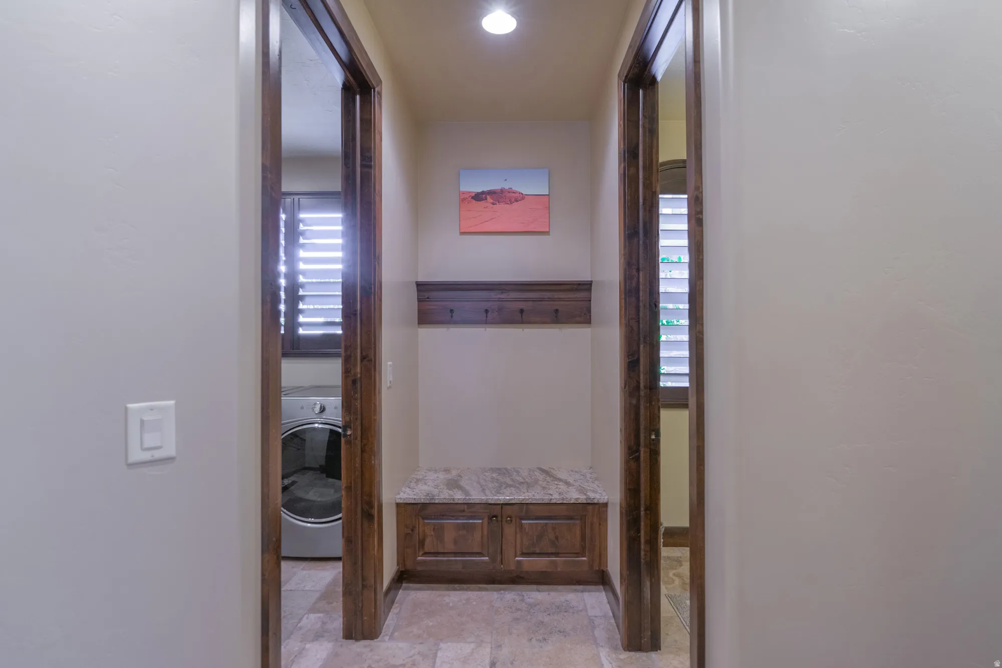 Hallway with washer / clothes dryer and light stone finish flooring