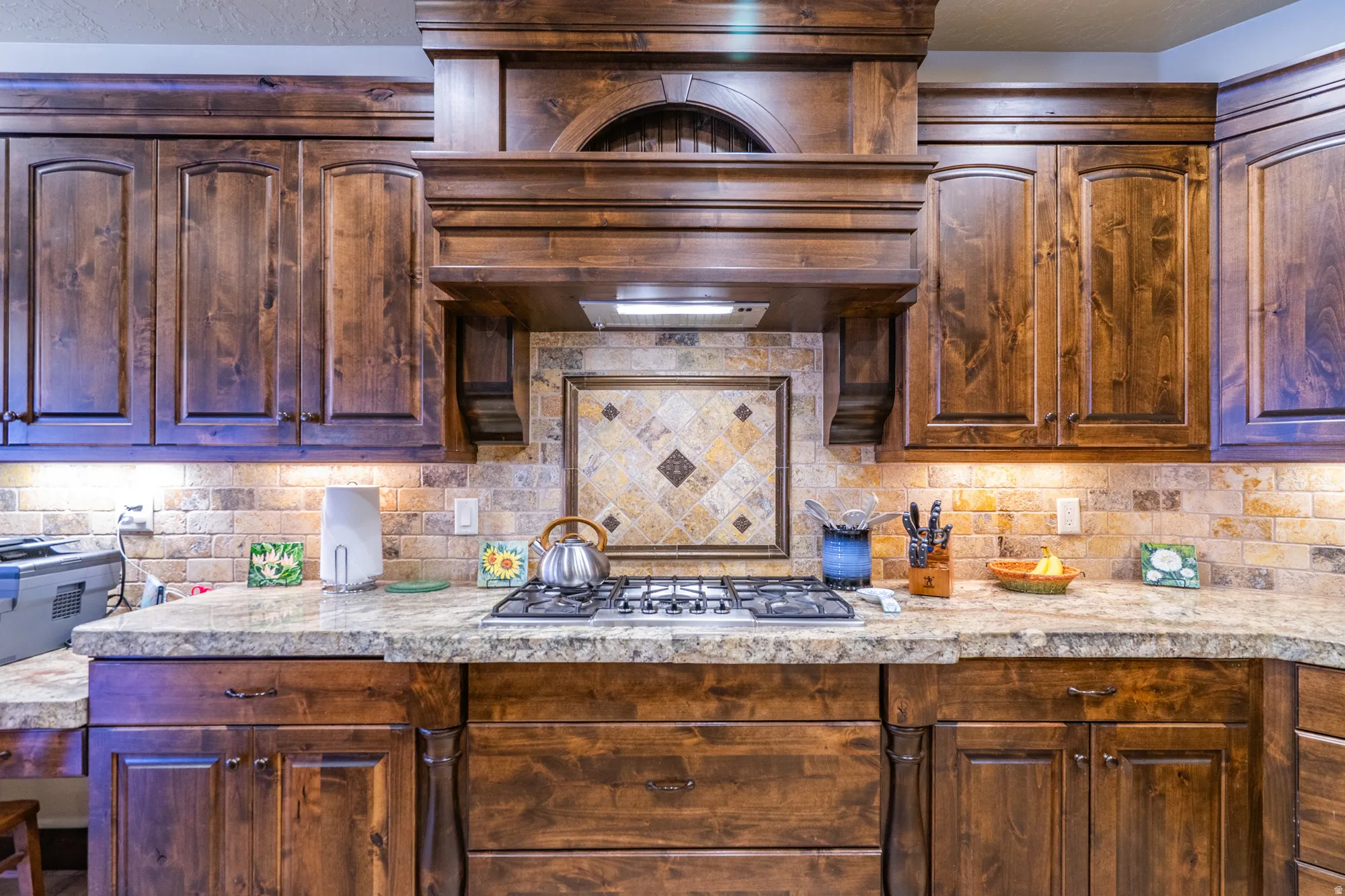 Kitchen with light countertops, tasteful backsplash, and stainless steel gas cooktop