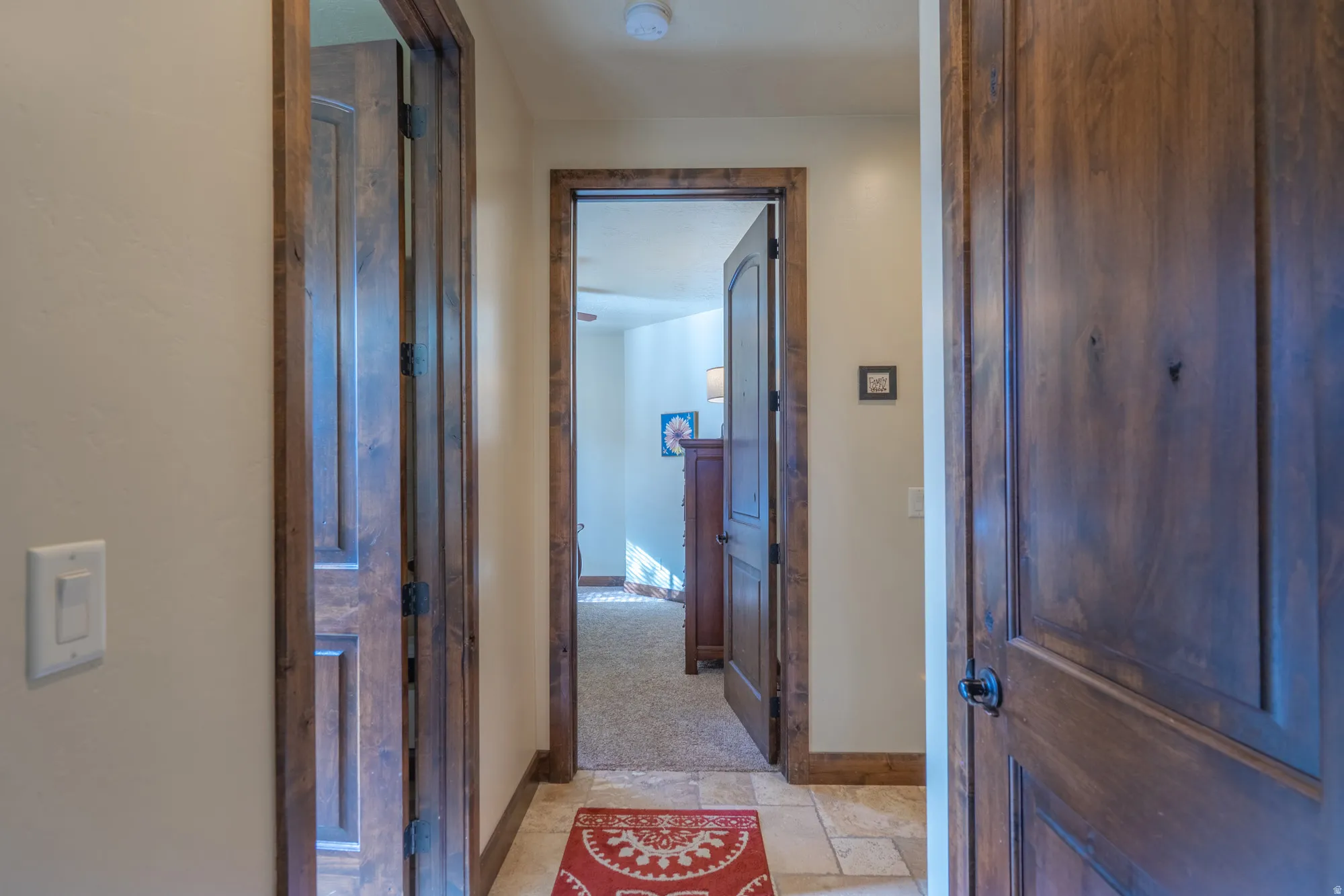 Corridor featuring baseboards and stone tile floors