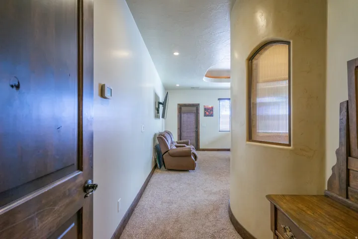 Corridor with light carpet, a textured ceiling, and recessed lighting