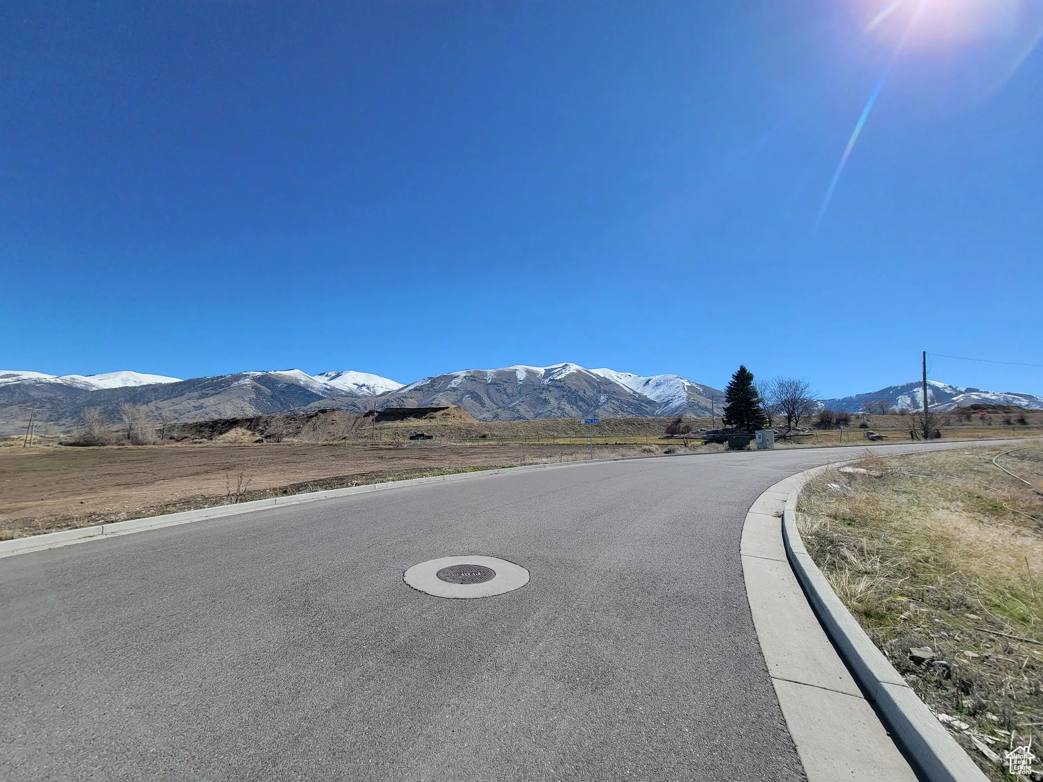 View of asphalt street with a mountain view and curbs