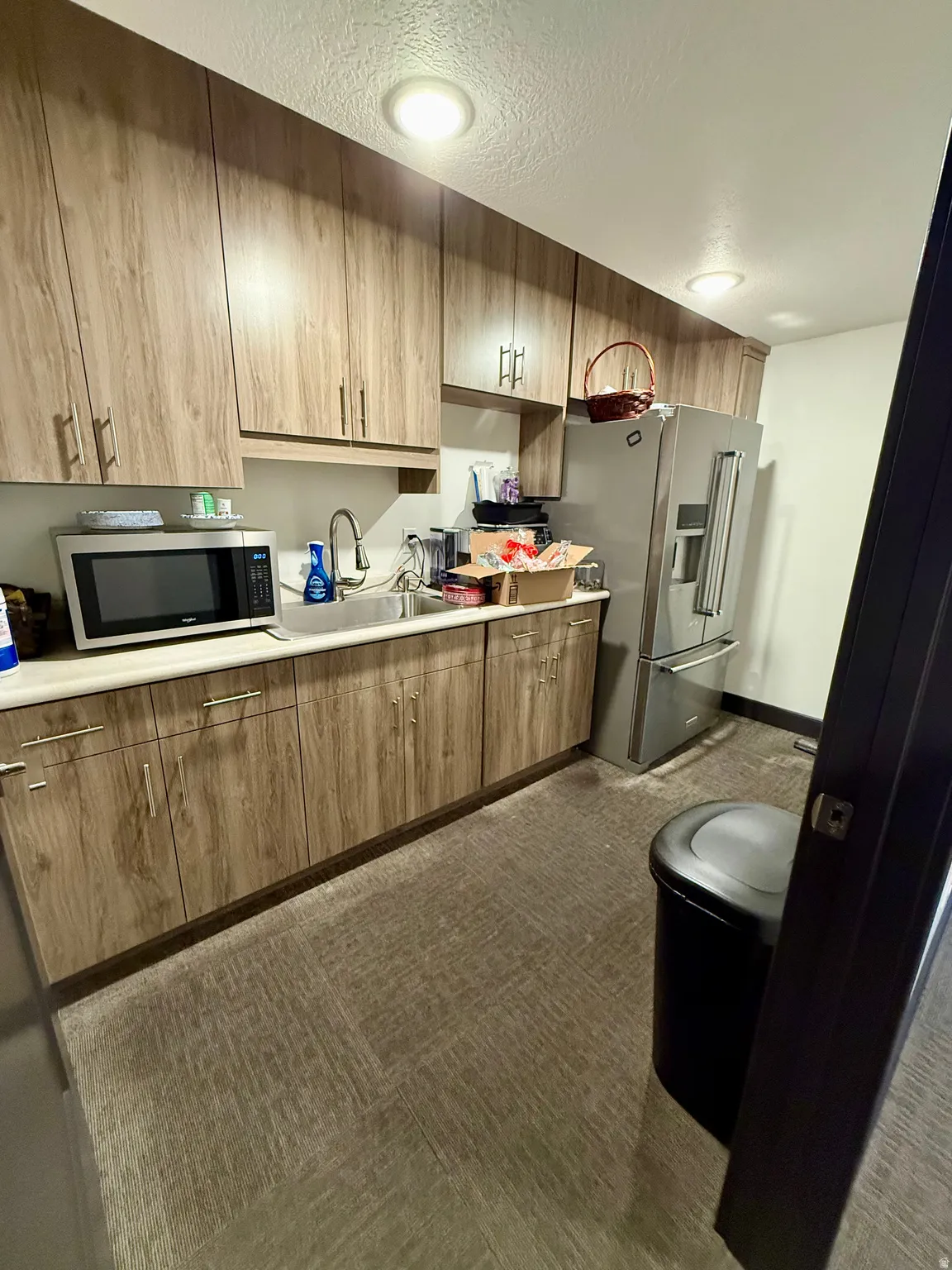 Kitchen featuring light countertops, a textured ceiling, and stainless steel appliances