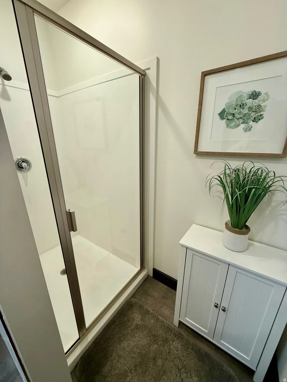 Bathroom featuring a stall shower and baseboards