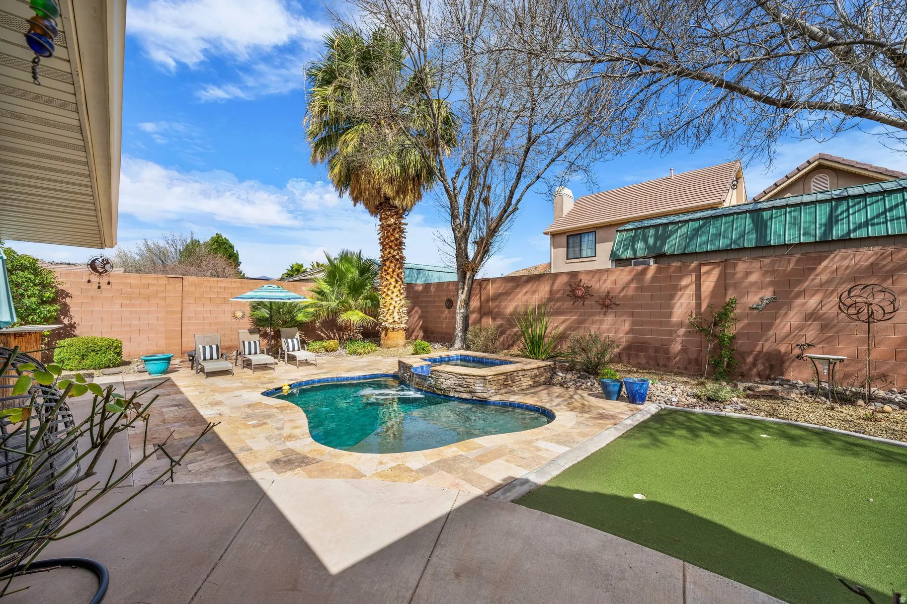Combined pool / hot tub featuring a fenced backyard and a patio