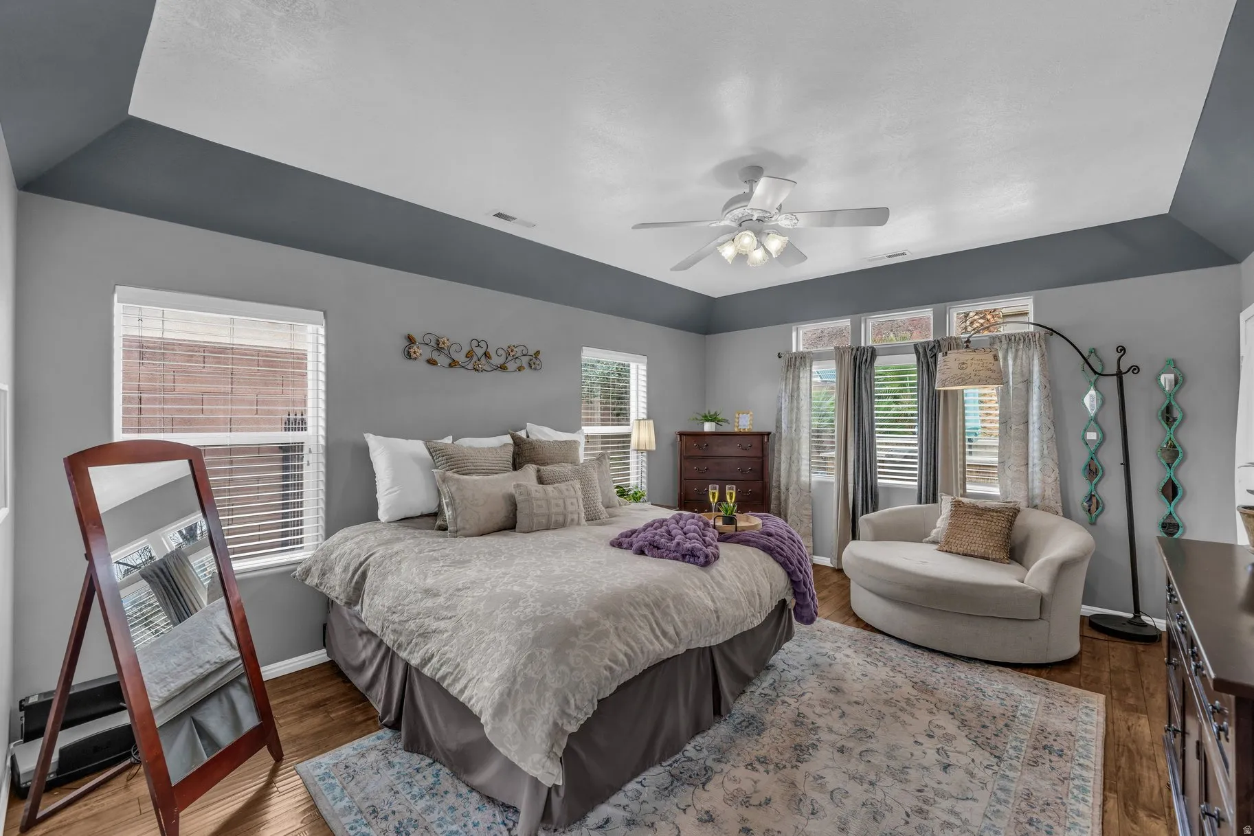 Bedroom with multiple windows, dark wood finished floors, and ceiling fan