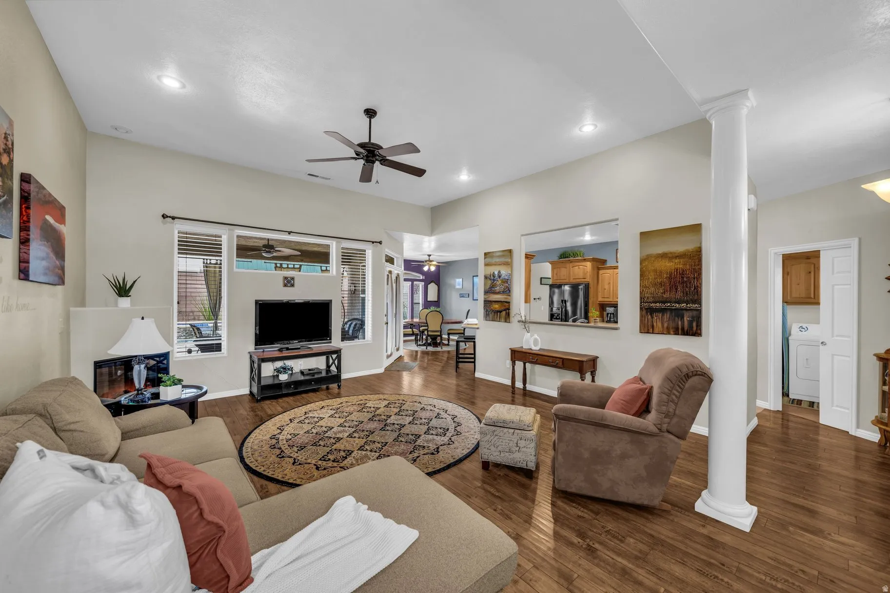 Living area featuring ornate columns, dark wood-style floors, ceiling fan, washer / clothes dryer, and recessed lighting