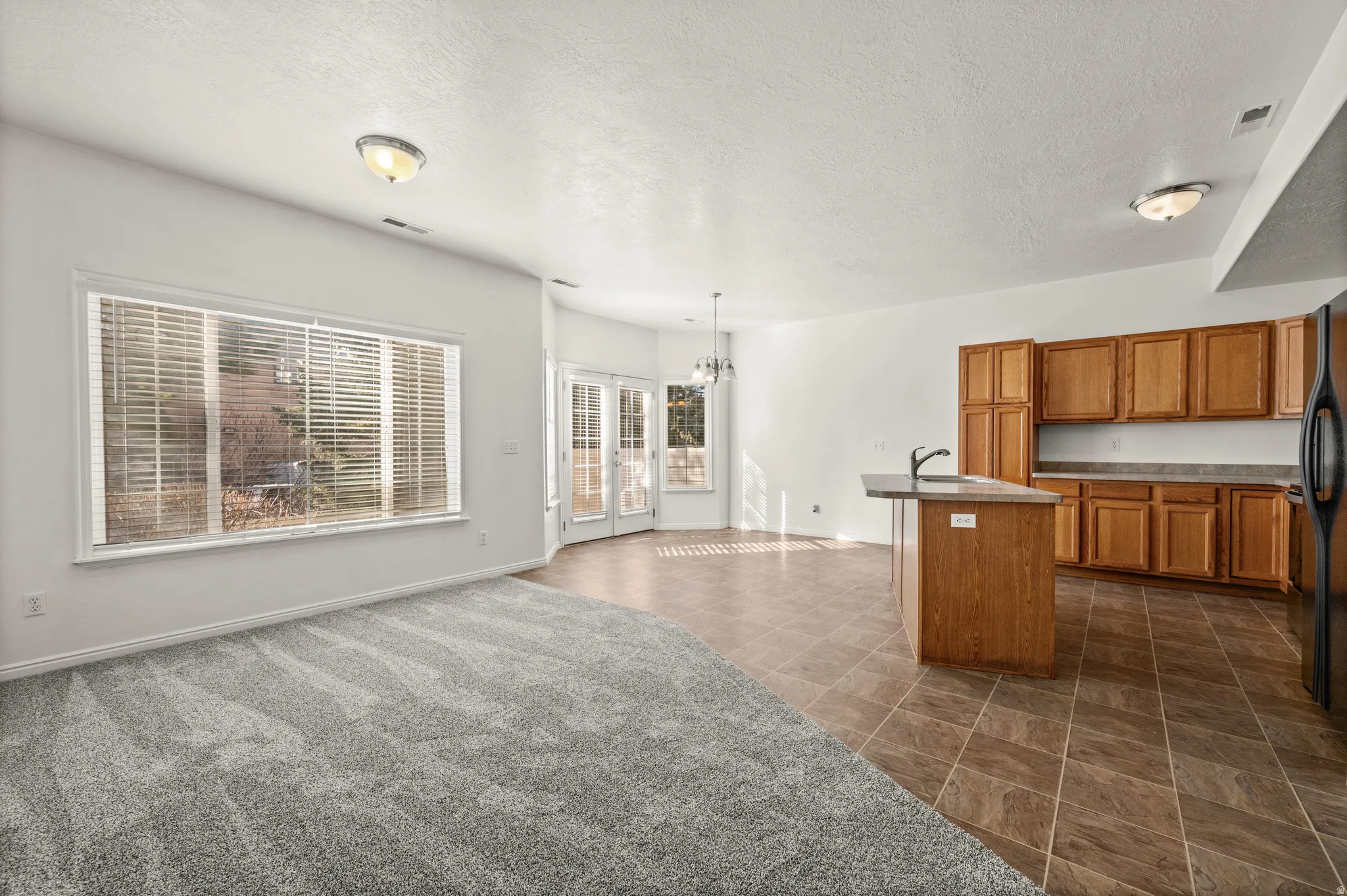 Open concept kitchen, featuring wood finish cabinets, kitchen nook and family room.