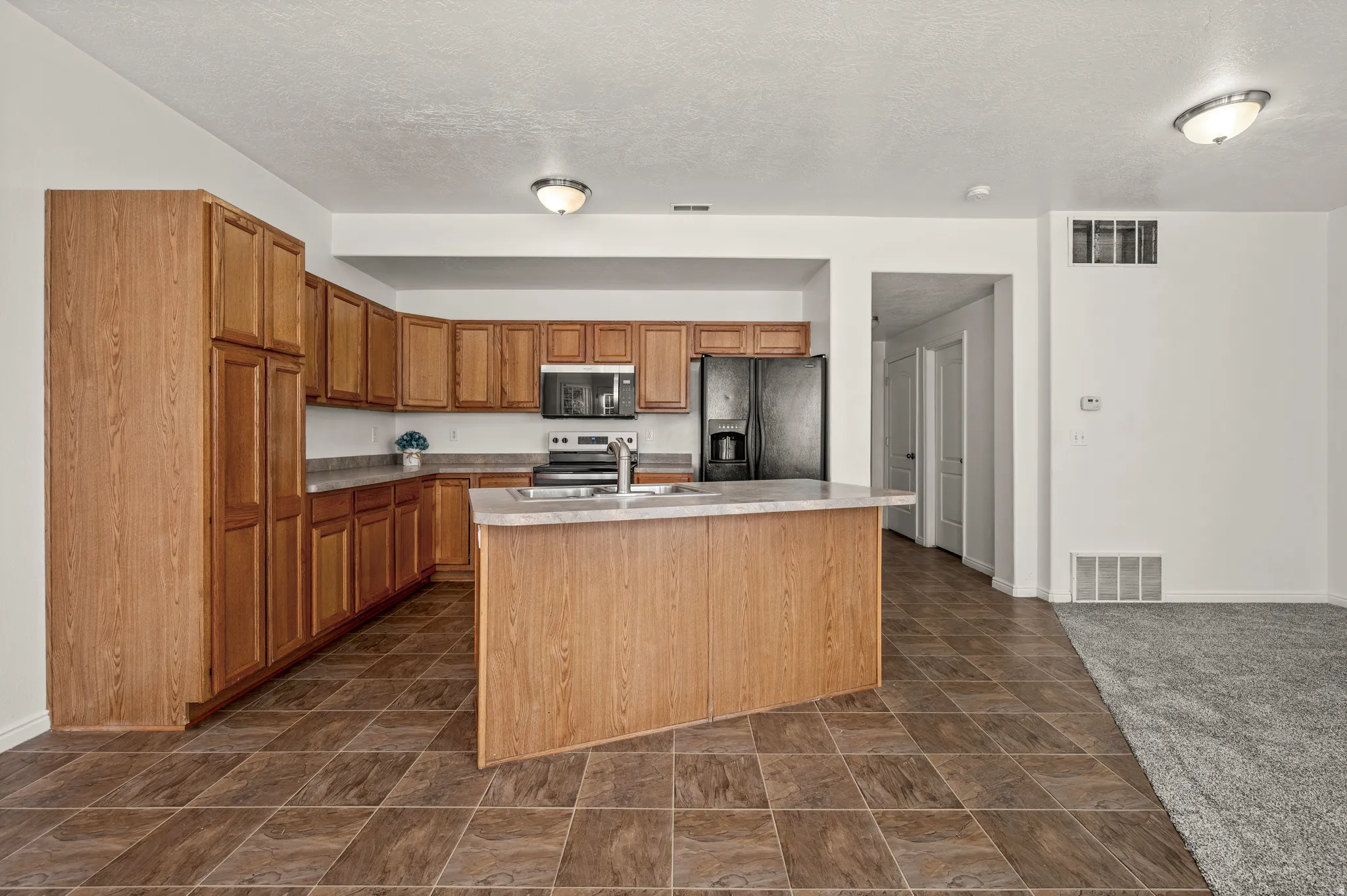 Open concept kitchen, featuring new oven, microwave, dishwasher.