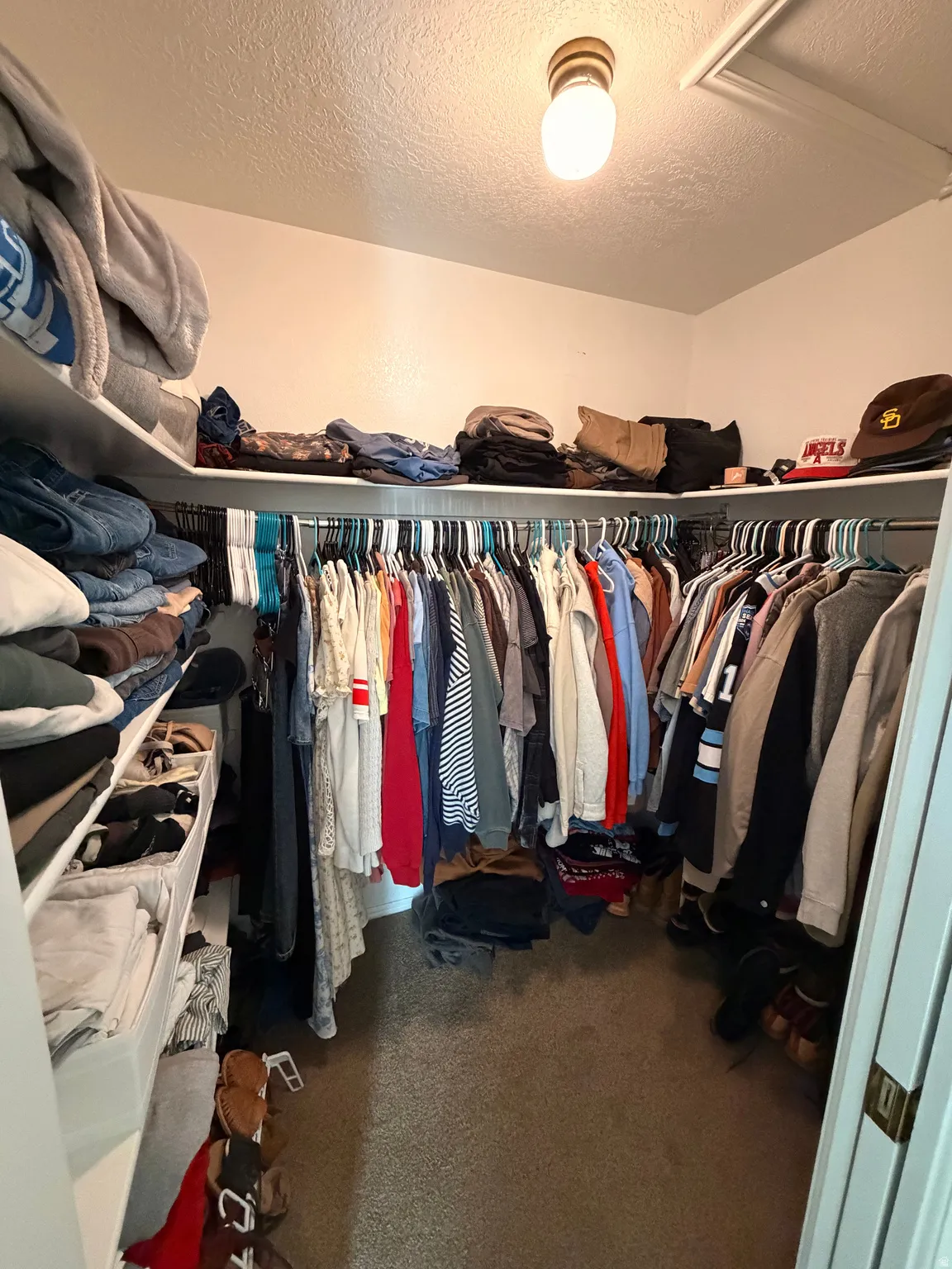 Walk in closet featuring dark carpet