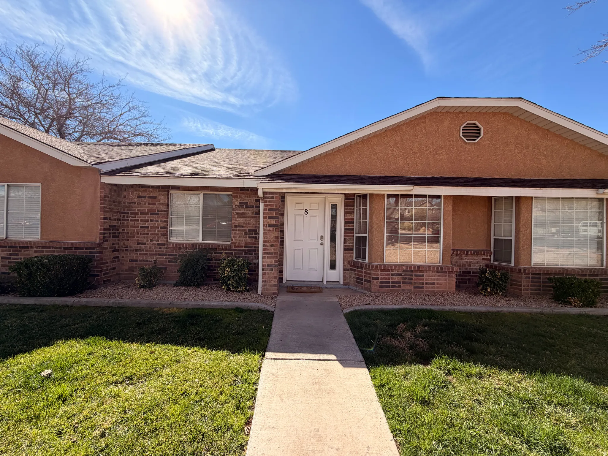 Ranch-style home with brick siding, a front yard, and roof with shingles