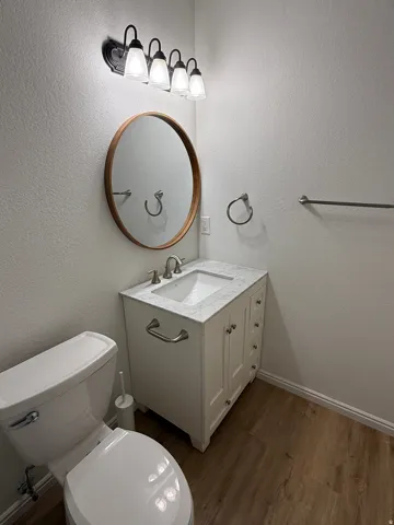 White vanity with a light-toned countertop, undermount sink, and brushed nickel fixtures