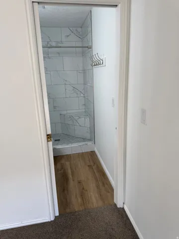 Walk-in shower with large format tile surround and integrated bench