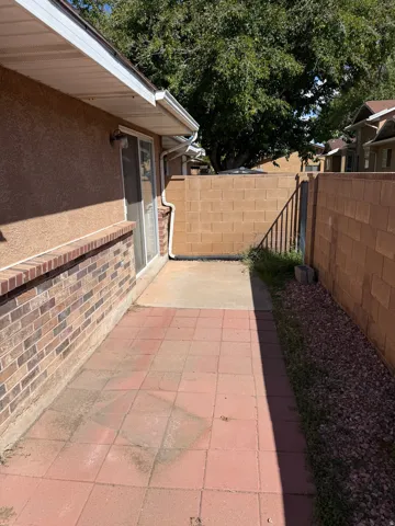 Outdoor patio area featuring red paver stones and a concrete slab