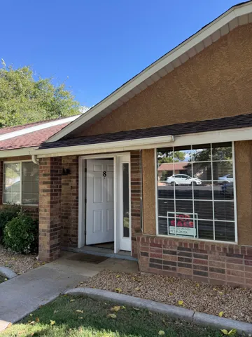 Brick and stucco facade with a shingle roof