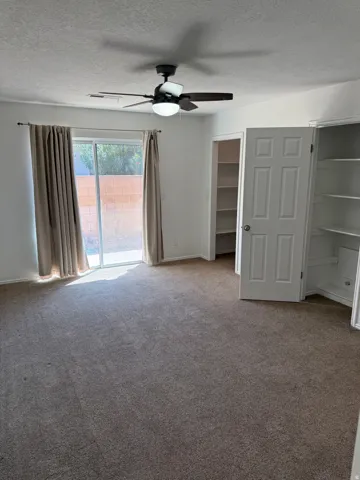 Recessed lighting, wood-finish ceiling fan, sliding glass door, built-in shelving, paneled door