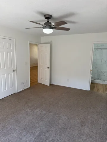 Carpeted flooring paired with a ceiling fan featuring an integrated light fixture